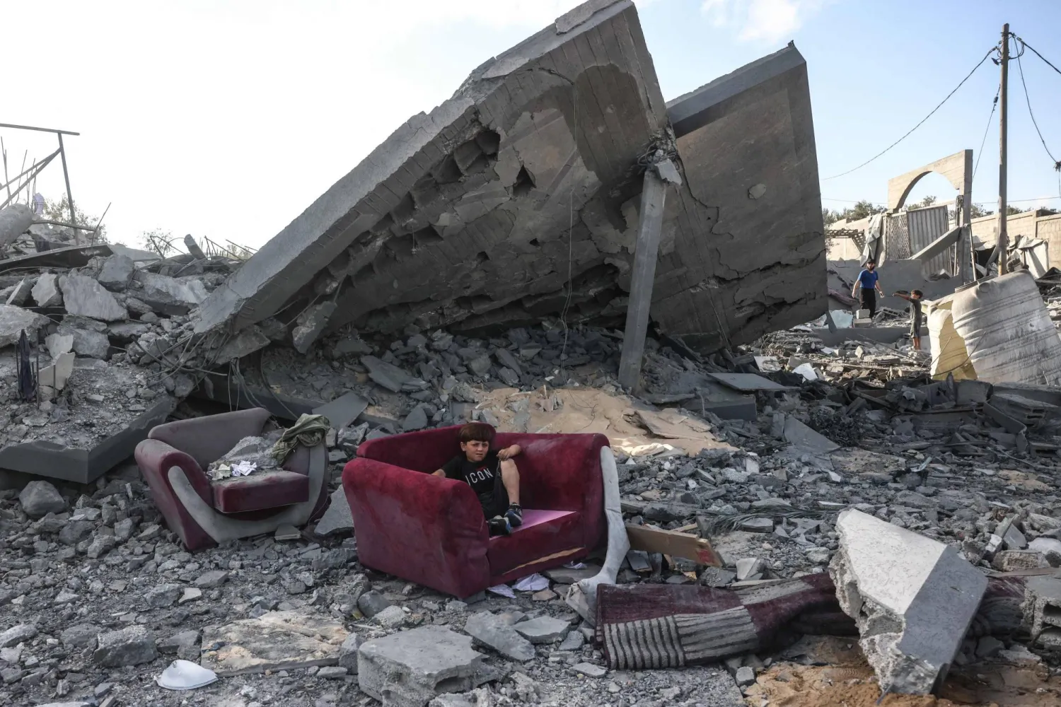 A boy sits on an armchair amid the rubble of a building near the site of an Israeli airstrike in Khan Yunis, southern Gaza Strip, on June 7, 2026. (Photo by Bashar Taleb / AFP)