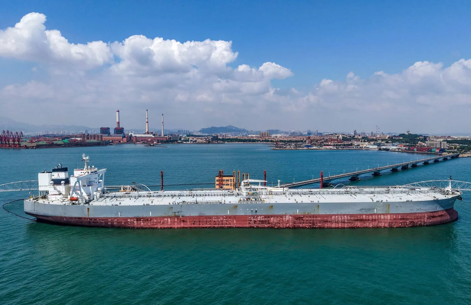 ناقلة نفط تُفرغ حمولتها من النفط الخام المستورد في ميناء تشينغداو بمقاطعة شاندونغ شرقي الصين (أ.ف.ب)