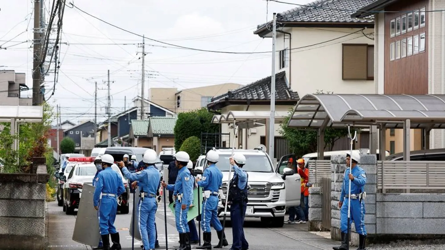  Police officers with shields and sticks search for a bear at a residential area after a black bear was spotted in Utsunomiya, Tochigi Prefecture, Japan, June 9, 2026. (Reuters)