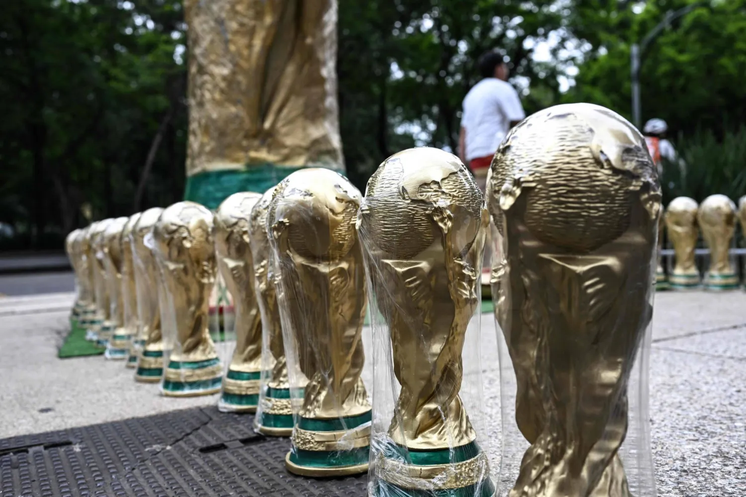  Souvenirs shaped like the FIFA World Cup trophy are displayed for sale on a street in Mexico City on June 8, 2026. (AFP) 