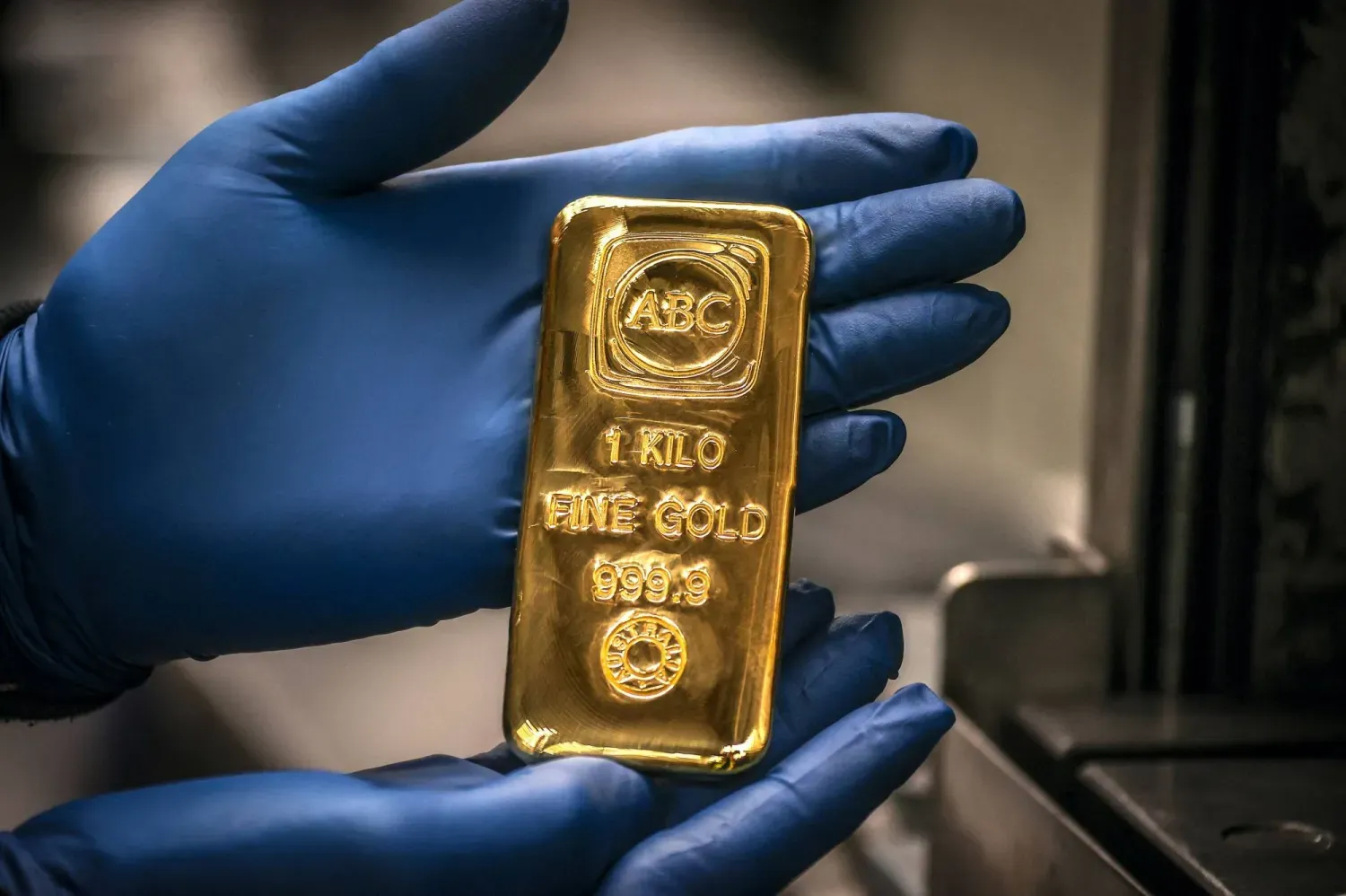 Bir işçi Sidney'deki rafineride bir kilogramlık altın külçesini gösteriyor (AFP)