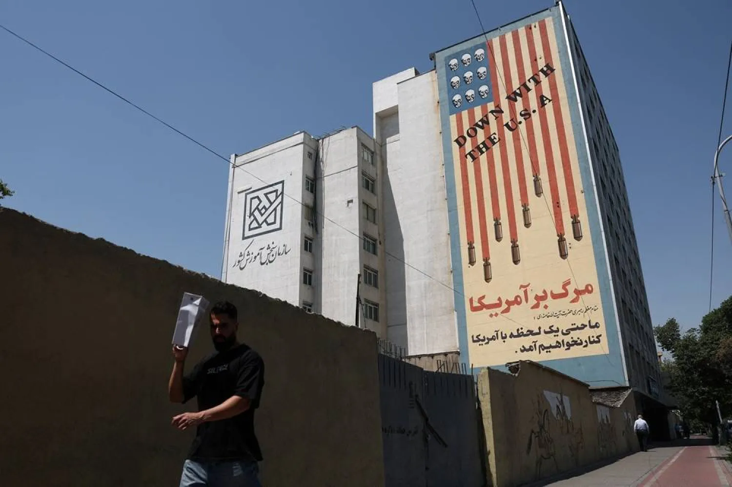 A man walks near an anti-US mural on a building in Tehran, Iran, June 9, 2026. Majid Asgaripour/WANA (West Asia News Agency) via Reuters