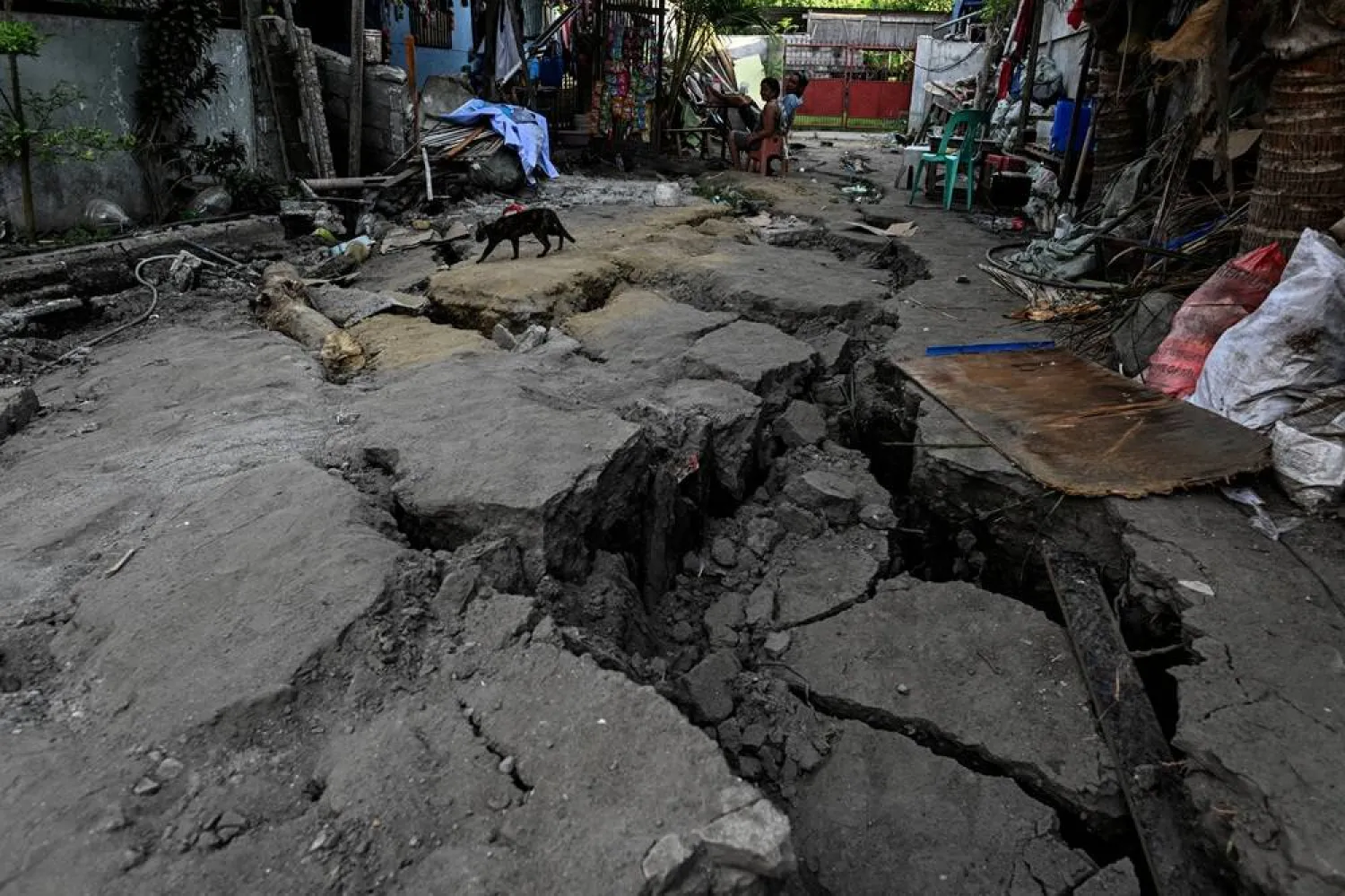  People sit outside their house on an earthquake-cracked street a day after the magnitude 7.8 quake in General Santos, southern Philippines, June 9, 2026. (Reuters)