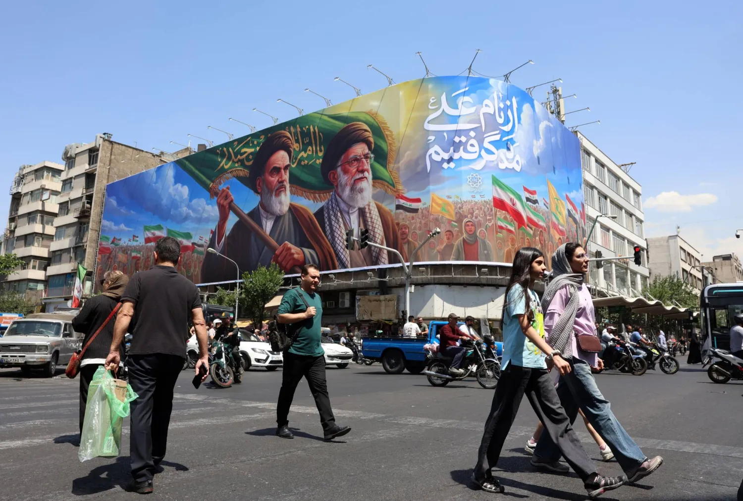 Iranians walk past a large billboard featuring late Iranian Supreme Leader Ruhollah Khomeini and Supreme Leader Ali Khamenei on a street in Tehran, Iran, 10 June 2026. EPA/ABEDIN TAHERKENAREH 