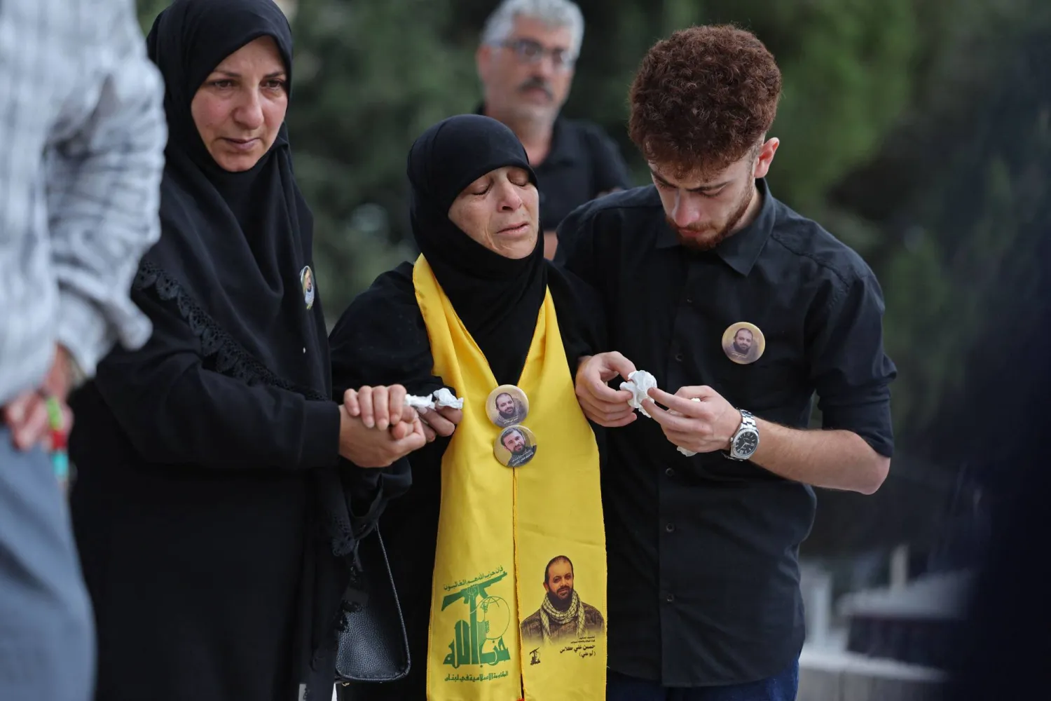 والدة مقاتل من «حزب الله» تبكيه خلال تشييعه بمقبرة مؤقتة في حارة صيدا جنوب لبنان (أ.ف.ب)