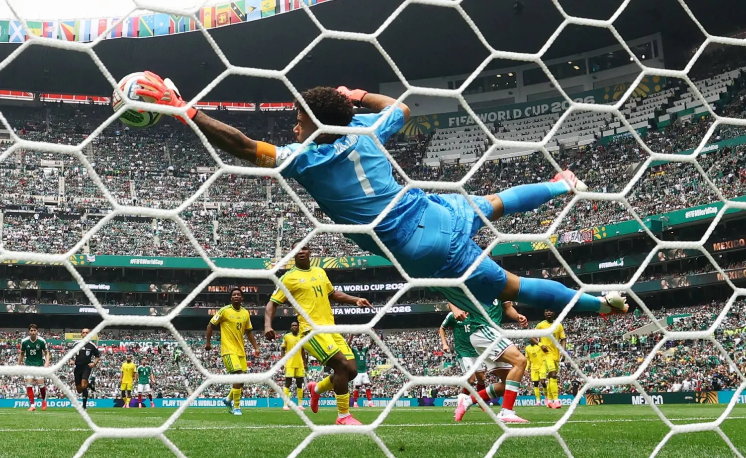 حارس منتخب جنوب أفريقيا رونوين ويليامز يتصدى لإحدى المحاولات المكسيكية (رويترز)