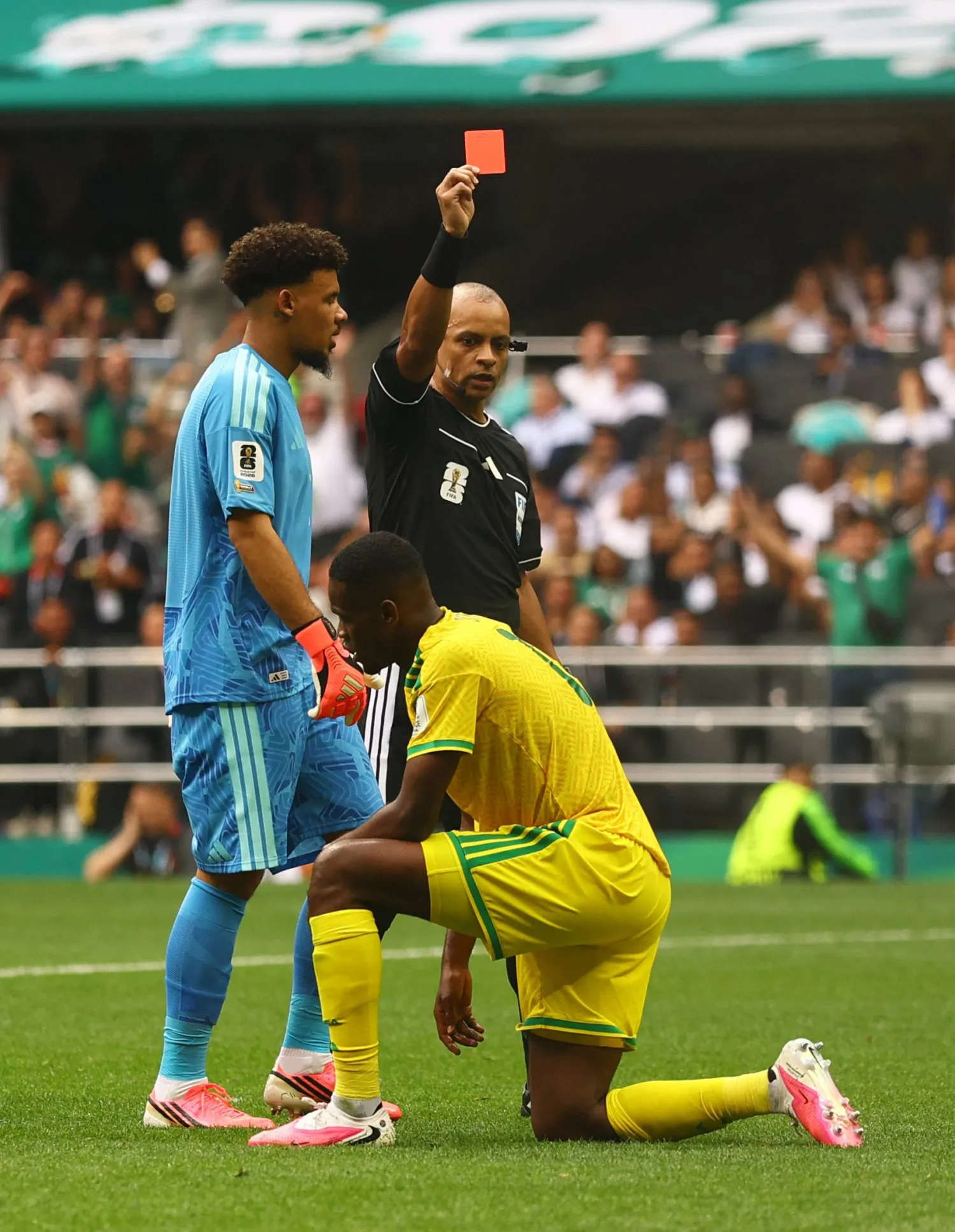 لاعب منتخب جنوب أفريقيا سفيلفو «يايا» سيتول يتلقى البطاقة الحمراء من الحكم البرازيلي ويلتون سامبايو (رويترز)