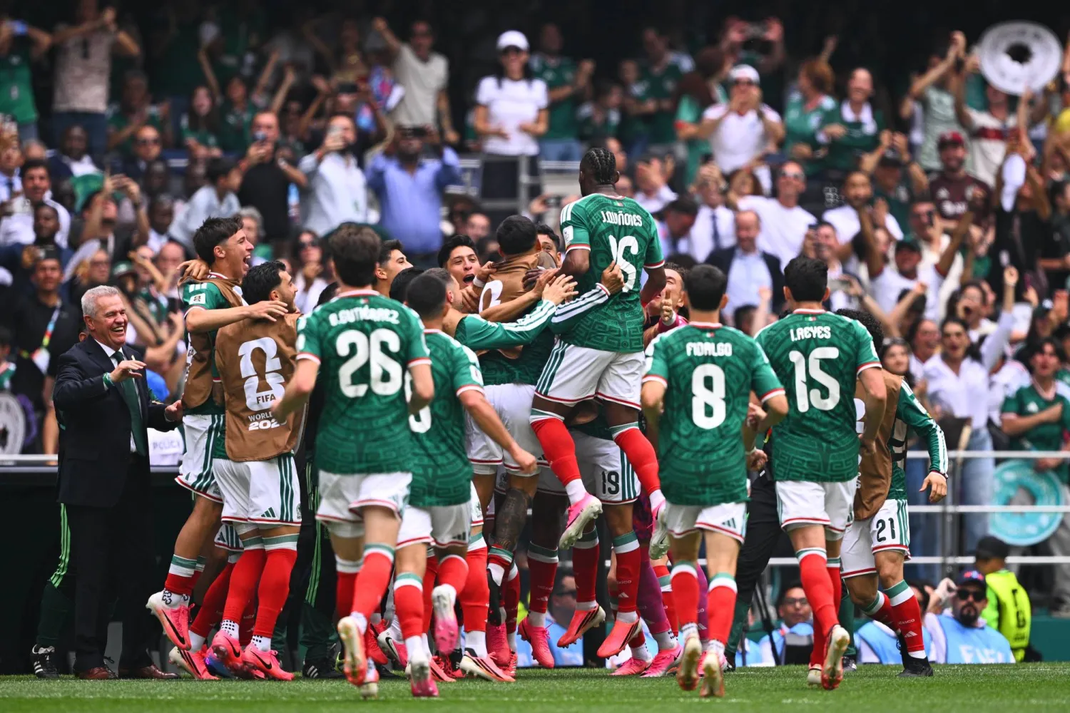 حتفل لاعب المنتخب المكسيكي جوليان كينيونيس مع زملائه بعد تسجيله الهدف الأول لمنتخبه خلال مباراة المكسيك وجنوب أفريقيا (د.ب.أ)