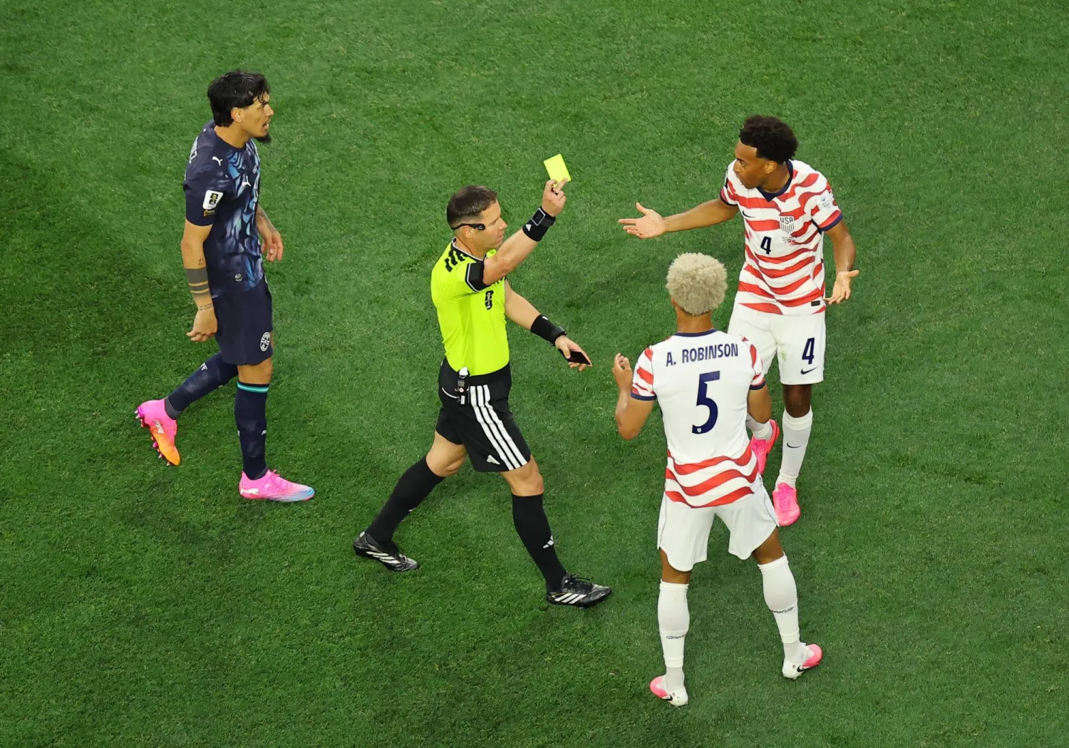 تيم ريم مدافع المنتخب الأميركي يتلقى الإنذار الذي سحب فيما بعد (رويترز)