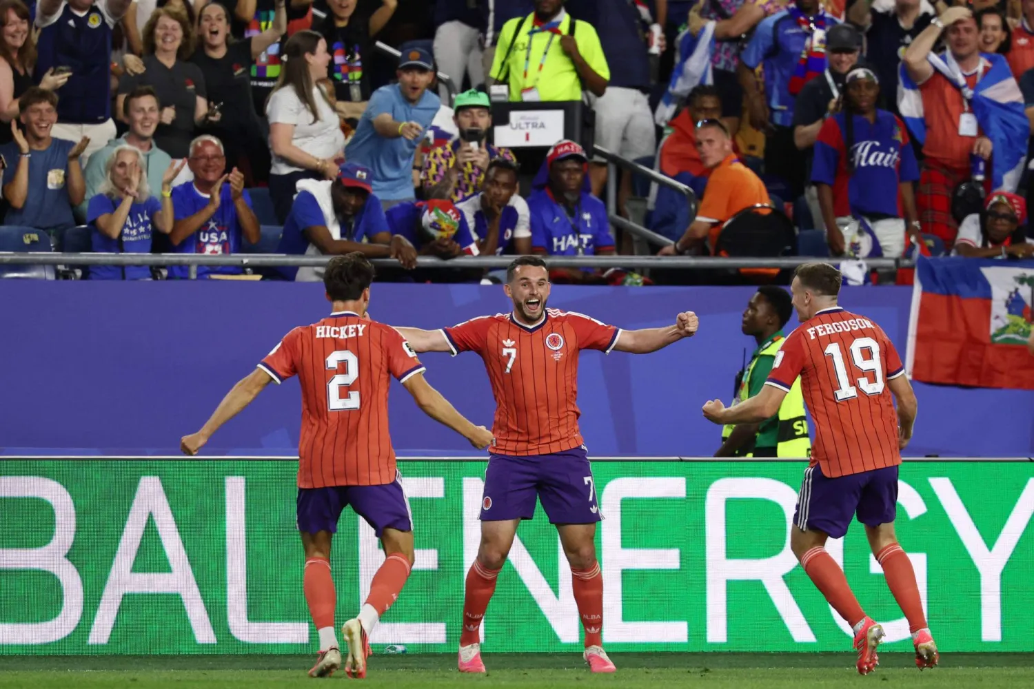 TOPSHOT - Scotland's midfielder #07 John McGinn celebrates with teammates defender #02 Aaron Hickey and midfielder #19 Lewis Ferguson after scoring his team's first goal during the 2026 World Cup Group C football match between Haiti and Scotland at the Boston Stadium in Foxborough on June 13, 2026. (Photo by FRANCK FIFE / AFP)