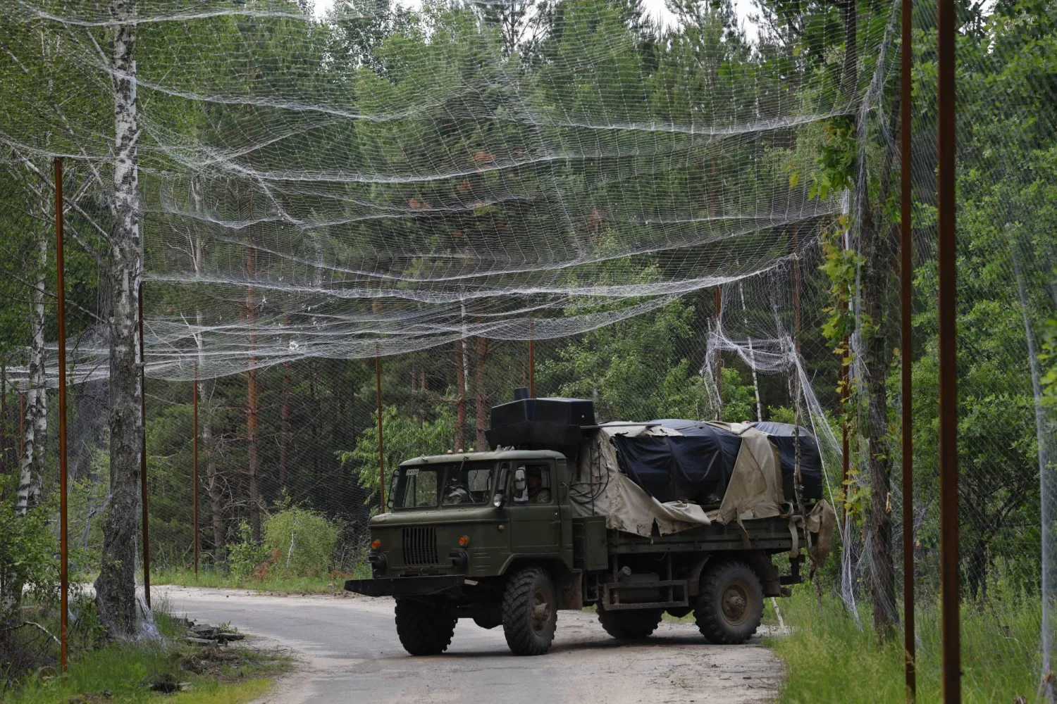 جنود من «اللواء 112» للدفاع الإقليمي الأوكراني يستقلون مركبة خلال قيامهم ببناء تحصينات في منطقة تشيرنوبل بالقرب من حدود بيلاروسيا (إ.ب.أ)