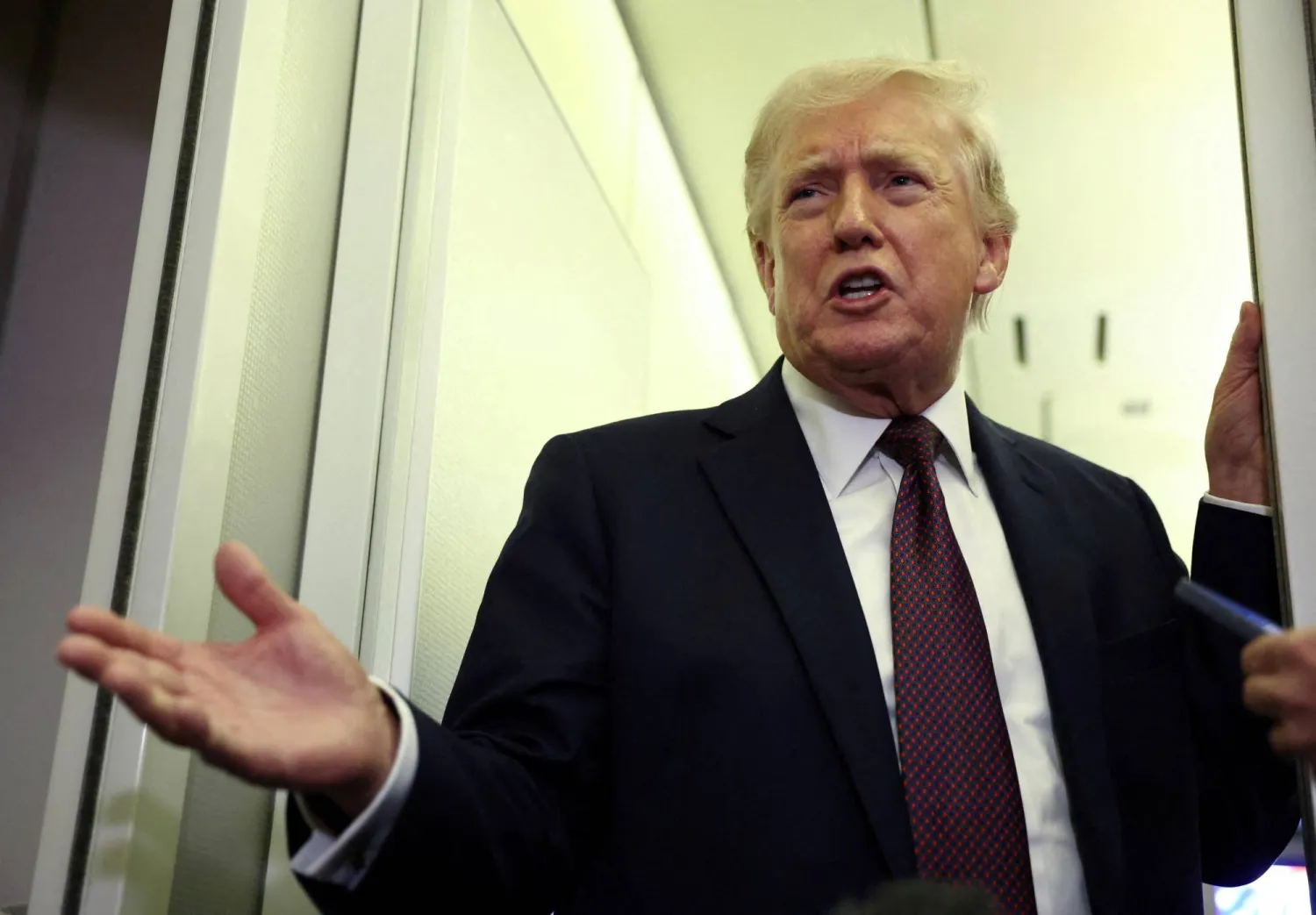 US President Donald Trump speaks to reporters aboard Air Force One on a flight back to Washington March 15, 2026. REUTERS/Kevin Lamarque/File Photo