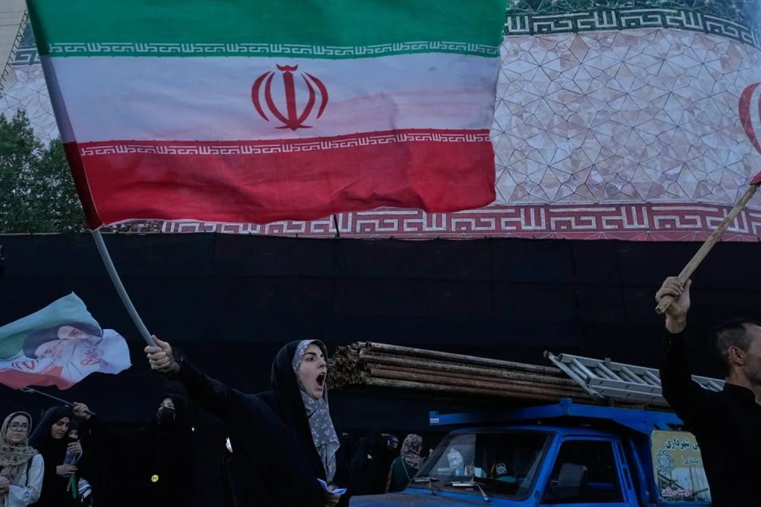  A woman waves an Iranian flags as she chants slogans against Iran and US talks at the revolution square in Tehran, Iran, Sunday, June 14, 2026. (AP) 