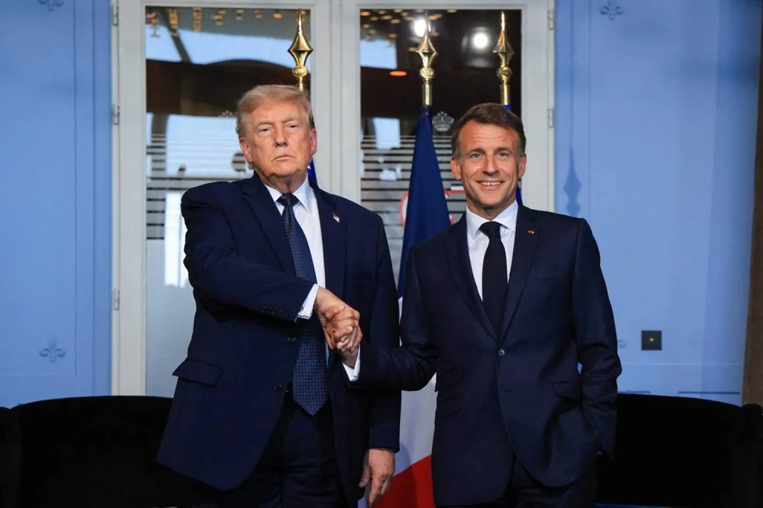 US President Donald Trump (L) shakes hands with France's President Emmanuel Macron during a bilateral meeting on the sidelines of the G7 summit, in Evian, central-eastern France on June 15, 2026. (AFP)