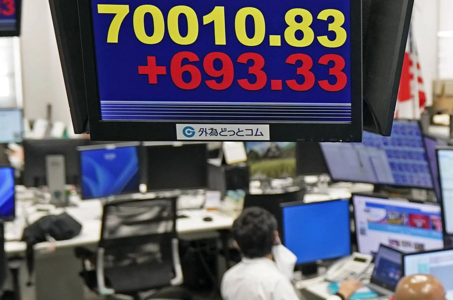 موظف في شركة تداول العملات الأجنبية يعمل تحت لوحة إلكترونية تعرض مؤشر«نيكي 225» الياباني، في طوكيو (أ.ب)