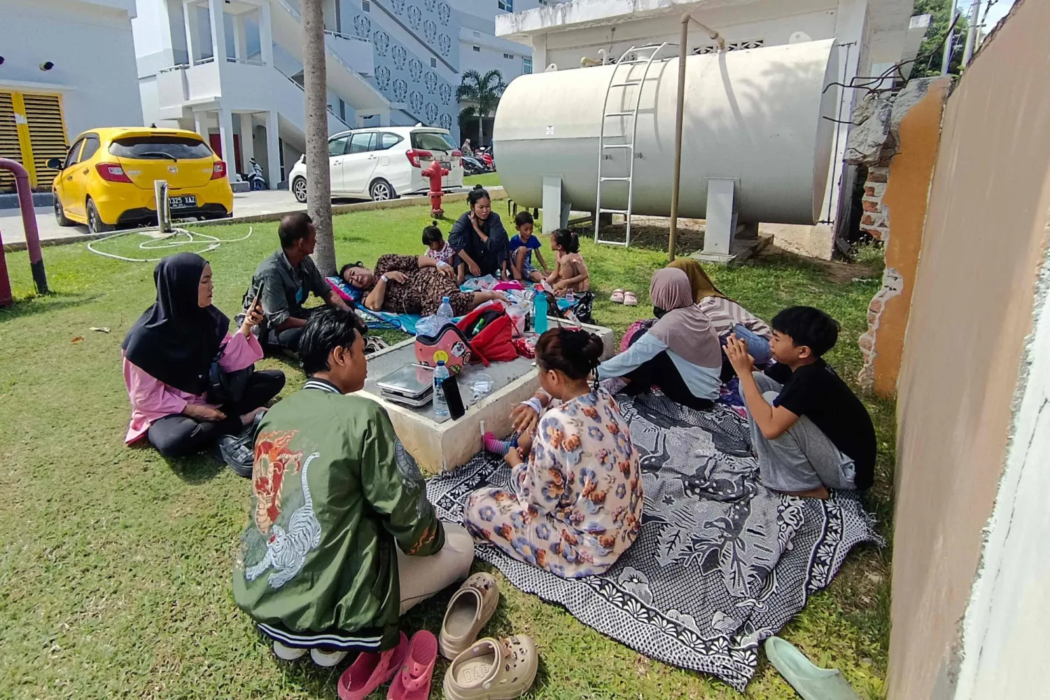 Patients and their family members evacuate outside Anutapura General Hospital following a 6.7 magnitude earthquake in Palu, Central Sulawesi, on June 16, 2026. (Photo by MUHAMMAD RIFKI / AFP)