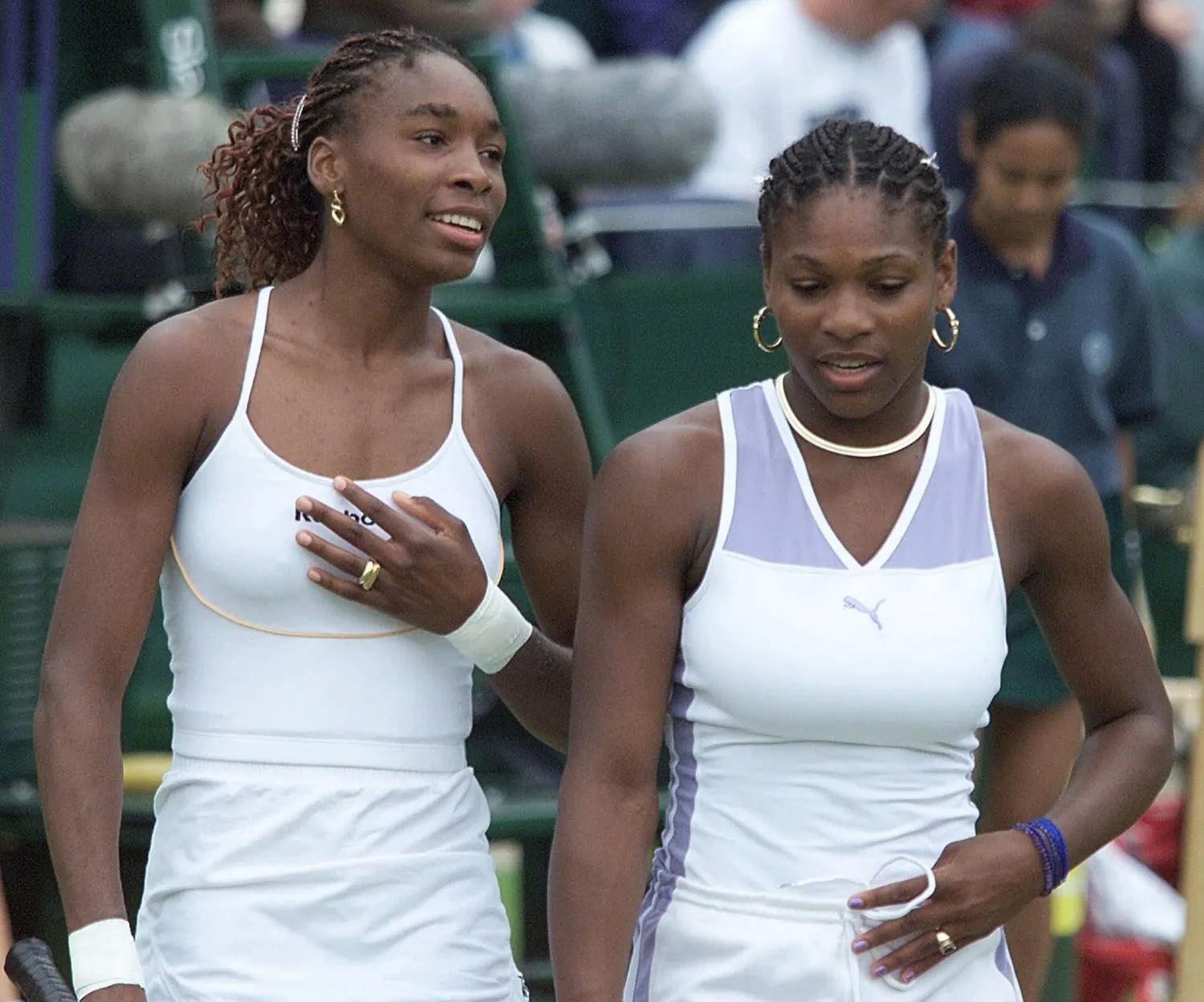 FILE -Venus Williams, left, and sister Serena talk together, during their Women's Doubles match against Irina Spirlea and Caroline Vis, at Wimbledon, July 4, 2000. (AP Photo/Alastair Grant, File)