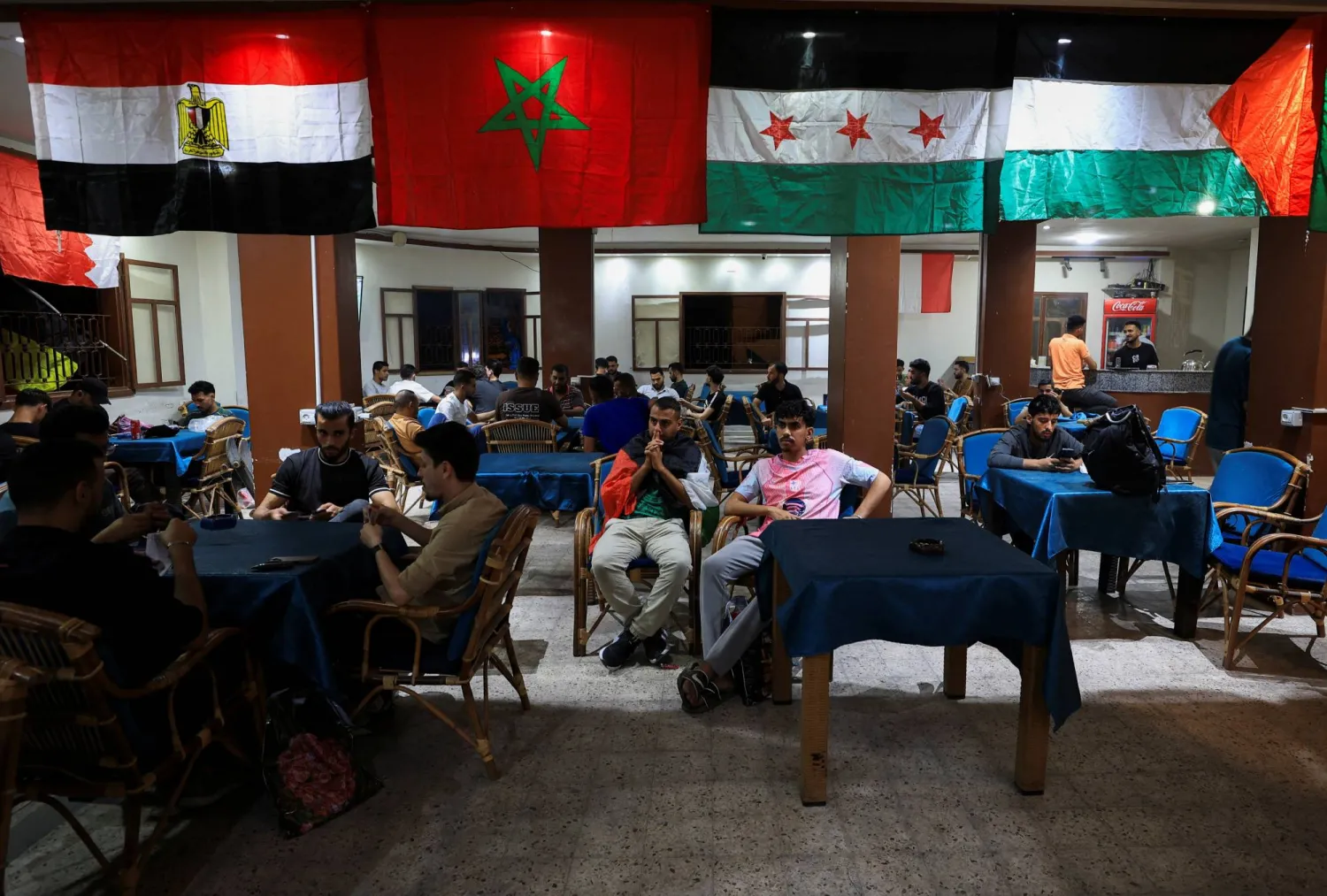 مشجعو كرة القدم الفلسطينيون يتابعون مباريات كأس العالم 2026 في مقهى بمدينة غزة (رويترز)
