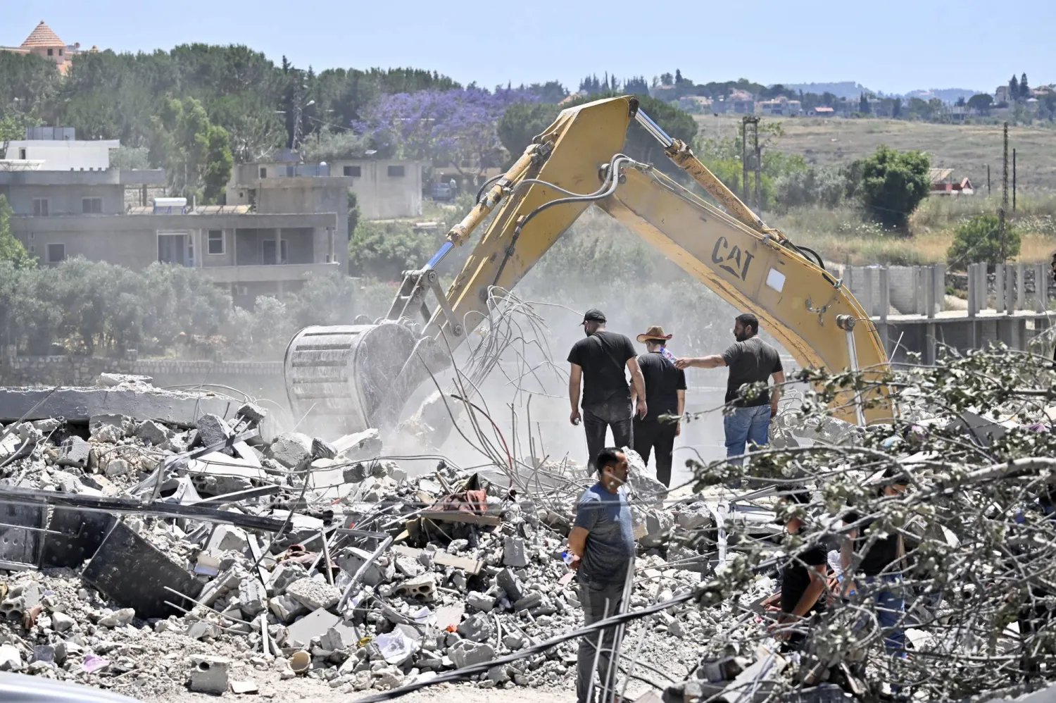سكان عادوا إلى قريتهم يستخدمون حفارة للبحث عن مفقودين تحت أنقاض مبنى مدمر في قرية تولين جنوب لبنان 16 يونيو 2026 (إ.ب.أ)