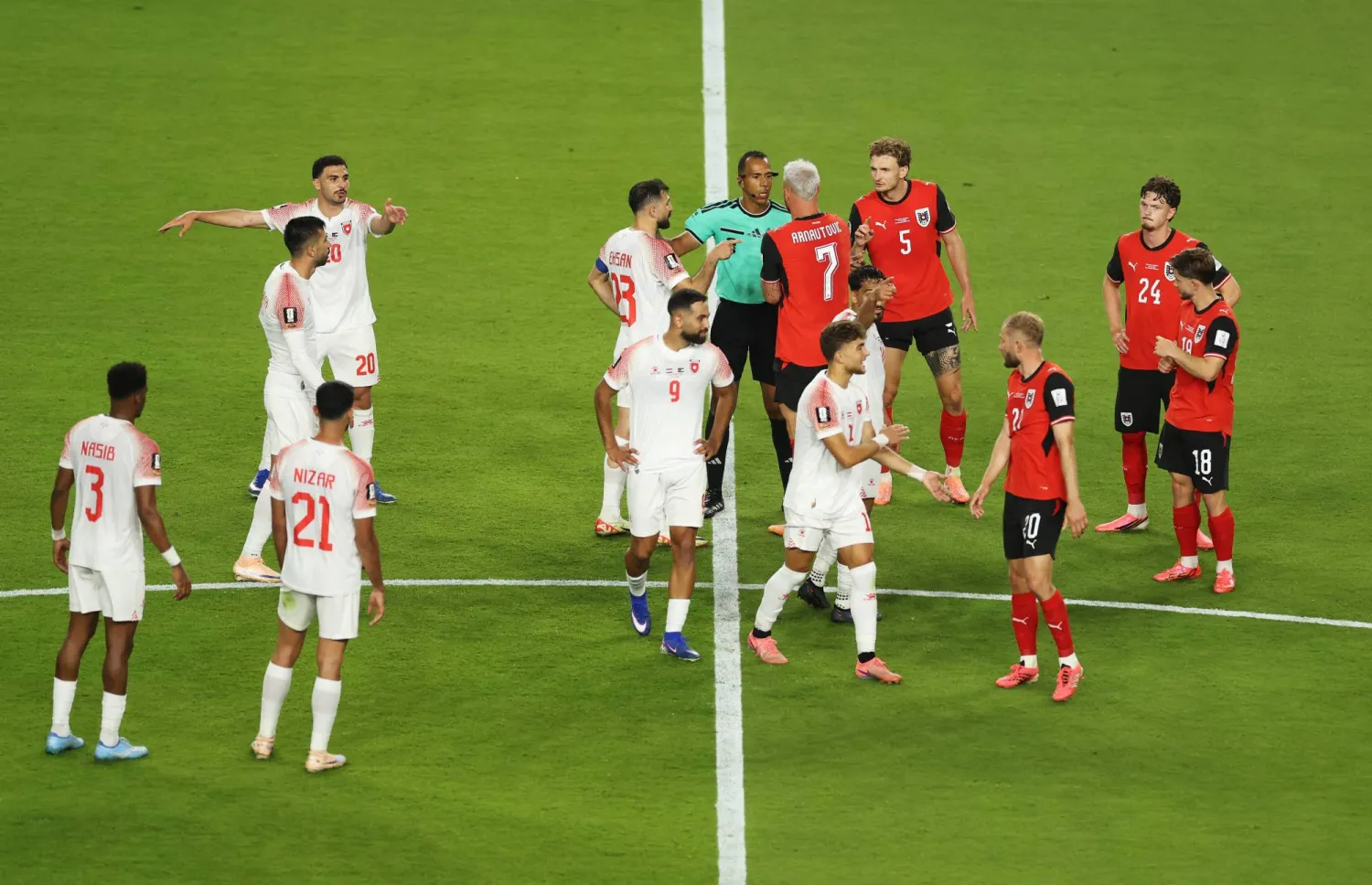 يتحدث اللاعبون مع الحَكم داهان بيدا بينما يُراجع حَكَم الفيديو المساعد هدف ماركو أرناوتوفيتش لاعب النمسا قبل أن يقرر إلغاءه (أ.ف.ب)