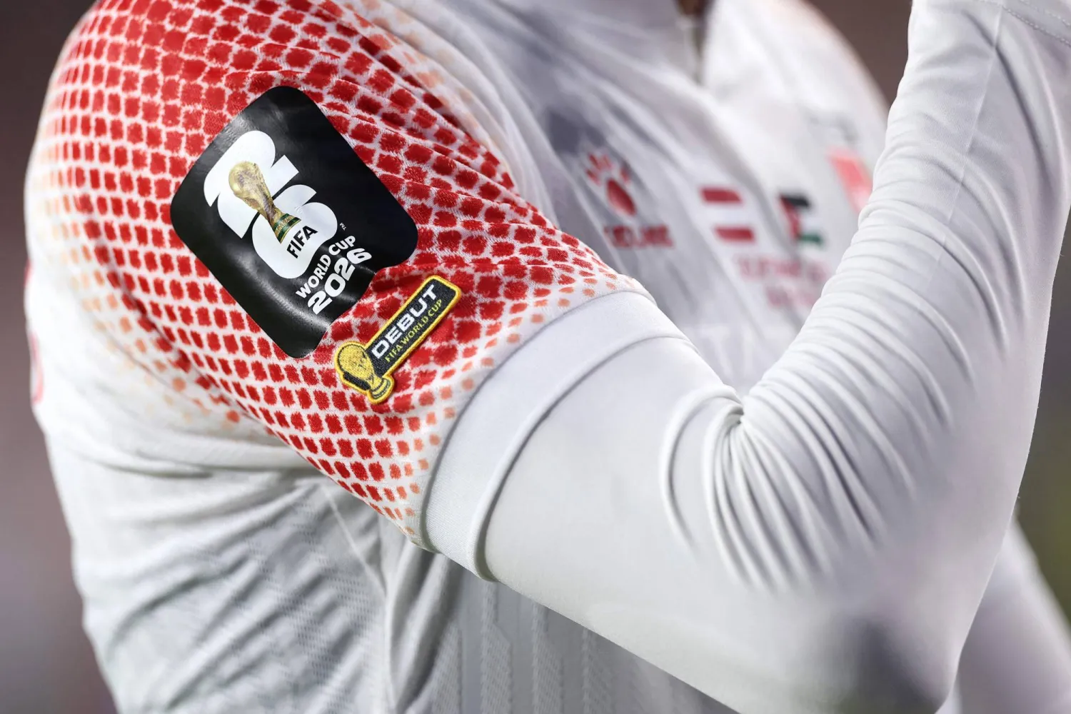 يظهر شعار المنتخب الأردني لأول مرة على قميص أحد لاعبي المنتخب الأردني ويرمز إلى الشماع الأحمر (أ.ف.ب)