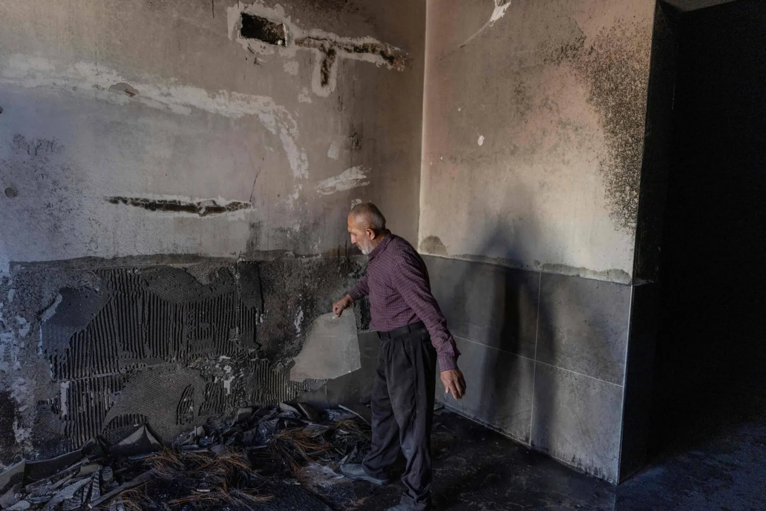 A Palestinian man inspects the damage inside a mosque burnt by Israeli settlers over night, in the Israeli occupied West Bank village of Jiljlia, just north of the West Bank city of Ramallah on June 17, 2026. (Photo by ilia YEFIMOVICH / AFP) / 