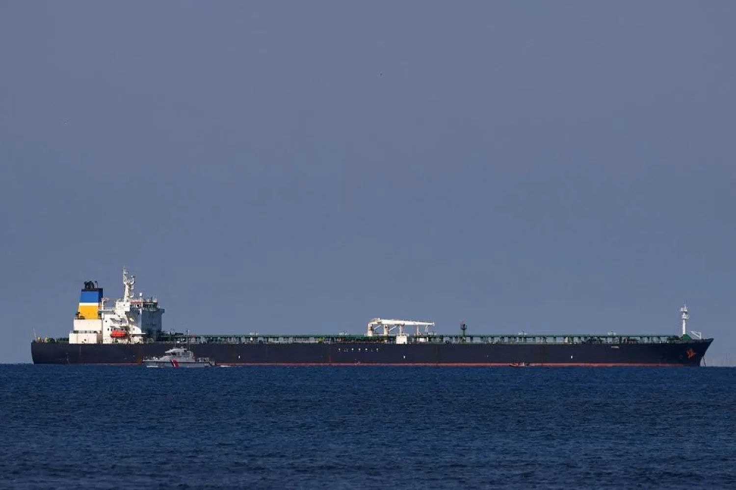 A French Maritime Gendarmerie boat patrols around the Mozambique-flagged oil tanker named Deyna, which France says is part of Russia's shadow fleet, off the port of Marseille-Fos in the Gulf of Fos-sur-Mer, near Martigues, France, March 23, 2026. (Reuters)