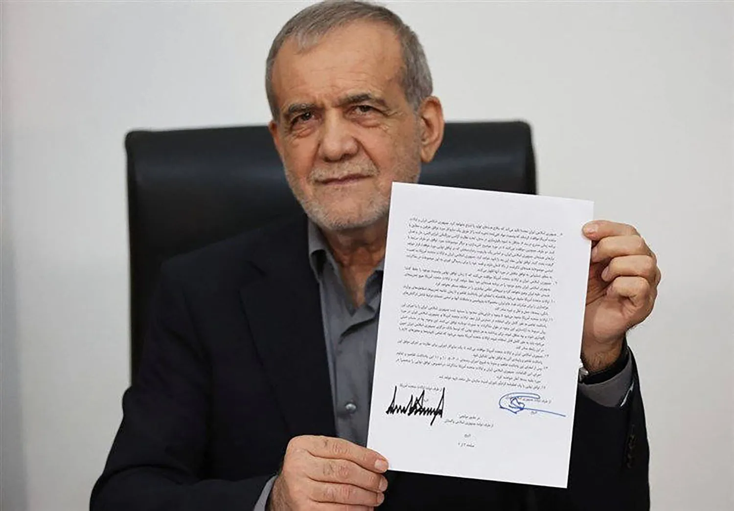بزشكيان يعرض نسخة من «مذكرة تفاهم إسلام آباد» الموقعة مع الرئيس الأميركي دونالد ترمب لإنهاء الحرب (التلفزيون الرسمي الإيراني - أ.ف.ب)