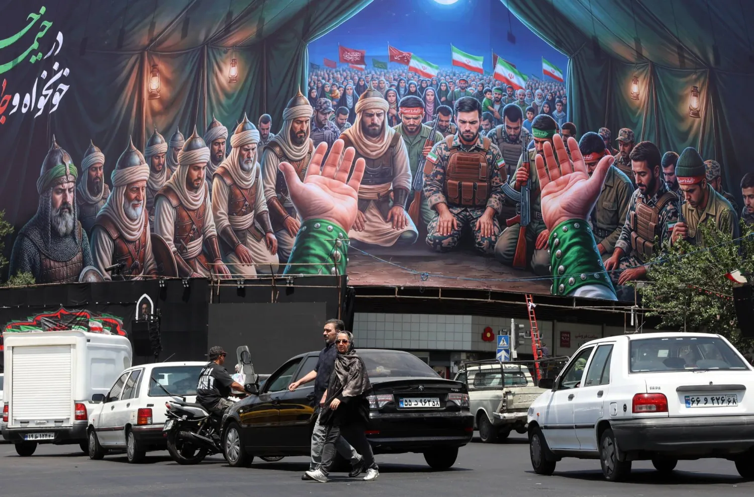 Iranians walk past a billboard at Enqelab square in Tehran, Iran, 18 June 2026. EPA/ABEDIN TAHERKENAREH