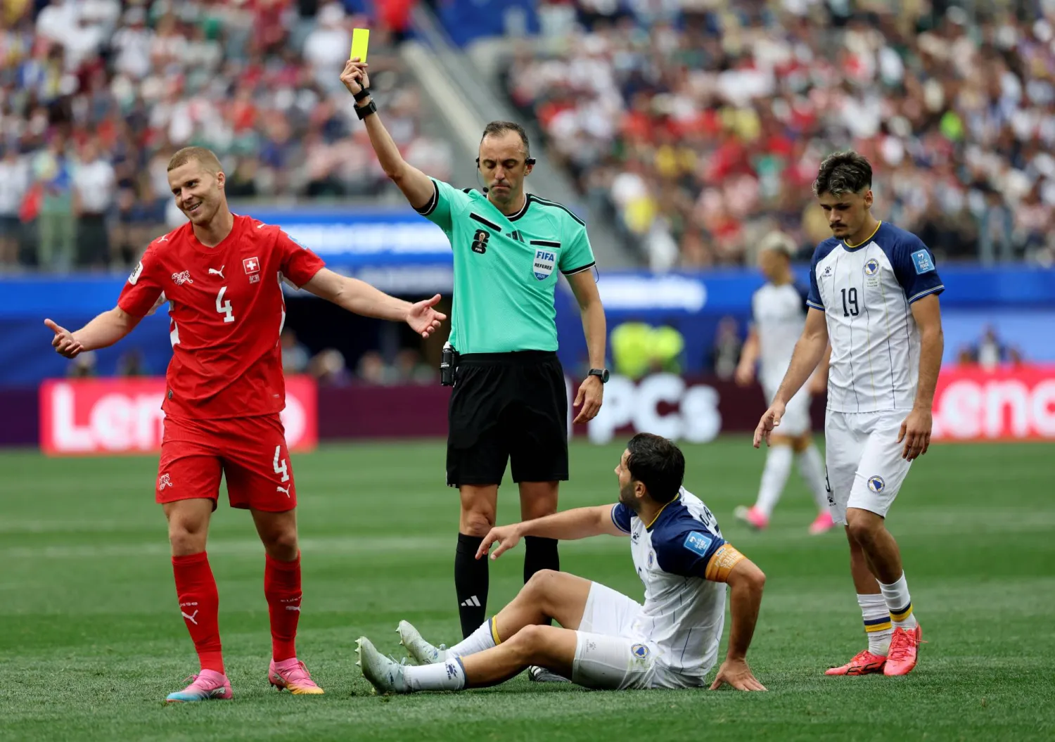 لاعب سويسرا نيكو إلفيدي يتلقى بطاقة صفراء من الحكم جواو بينهيرو (رويترز)