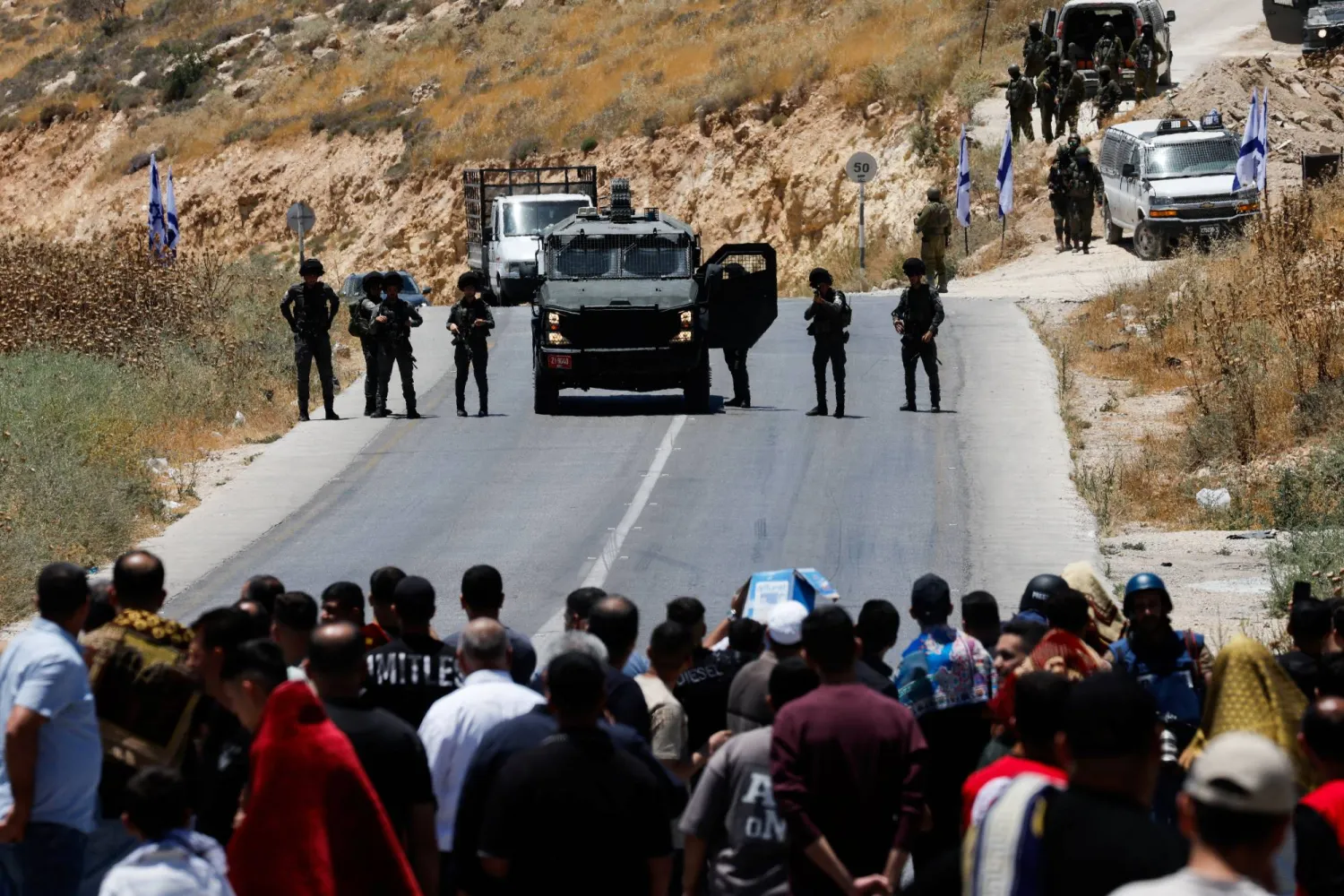 الجيش الإسرائيلي يغلق الطريق في حين يحتج فلسطينيون على الاستيطان قرب الخليل بالضفة الغربية المحتلة الجمعة (رويترز)
