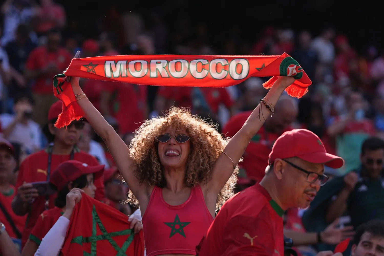 مشجعة مغربية تلوح بعلم بلادها (أ.ب) 