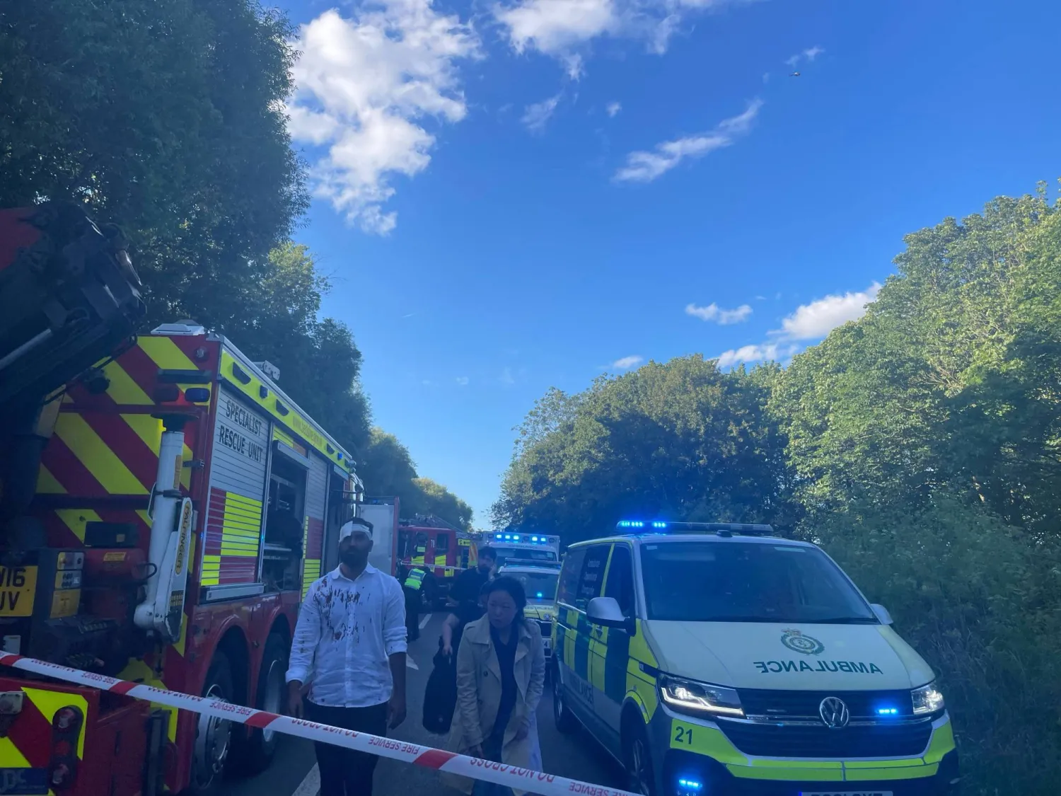 An injured man walks as emergency service workers gather near the scene of a collision involving two trains near Bedford, Britain, June 19, 2026. Picture taken with a mobile phone. Dr Pete Knapp/via REUTERS  