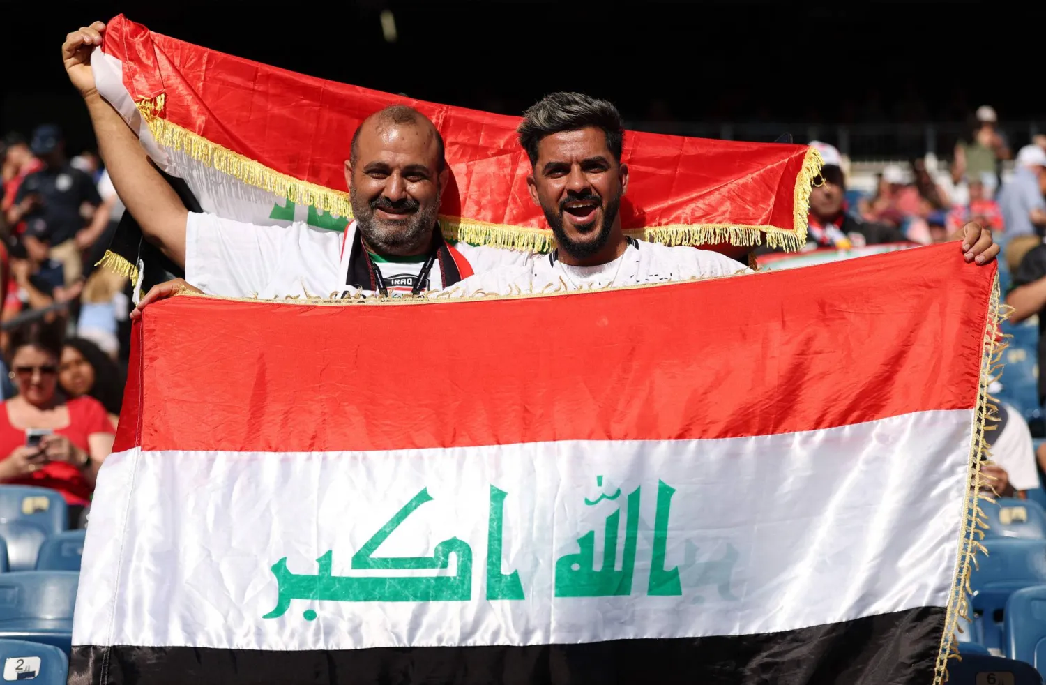 عراقيان يحملان علم بلديهما أمام النرويج (أ.ف.ب)