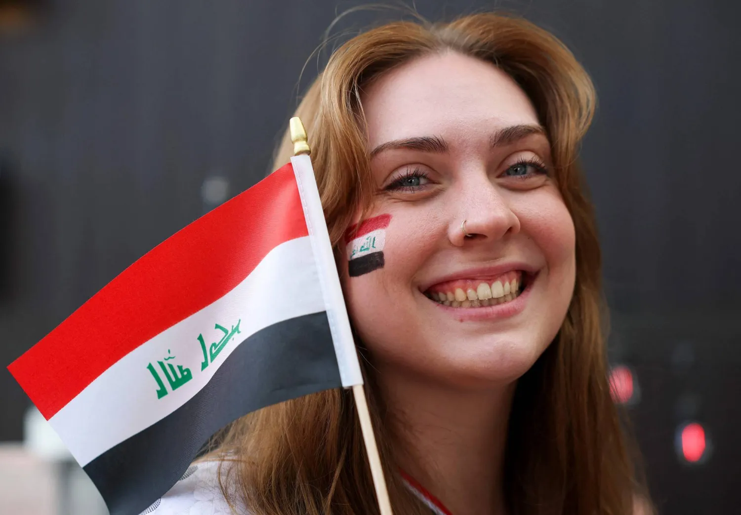 عراقية تحمل علم بلادها (أ.ف.ب)