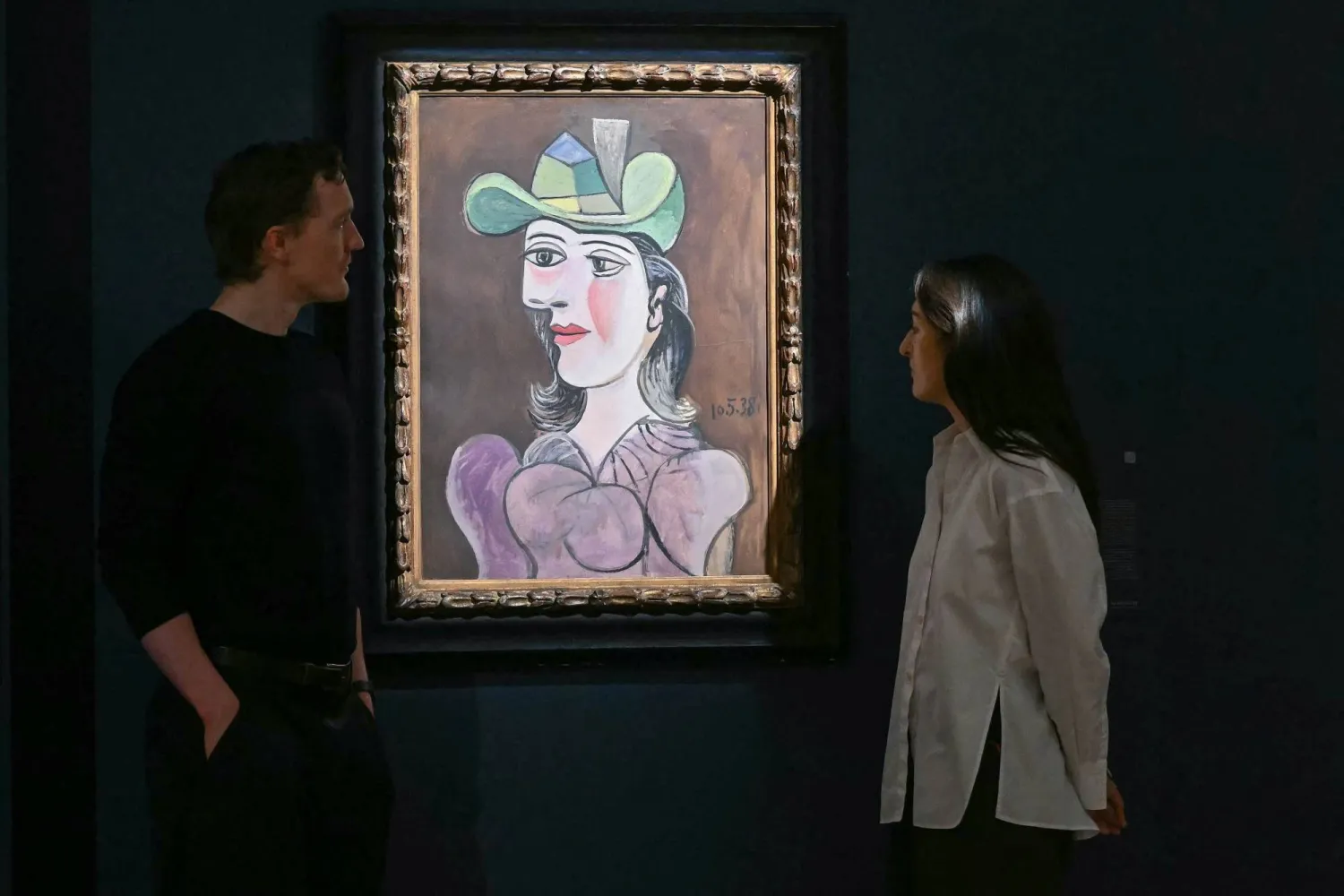 Staff members pose next to Pablo Picasso's 'Buste de femme', during a media preview by Sotheby's in central London on June 11, 2026, to highlight masterpieces from the Lewis Collection, estimated to be worth some 200 million pounds (267 million USD). (Photo by JUSTIN TALLIS / AFP) 