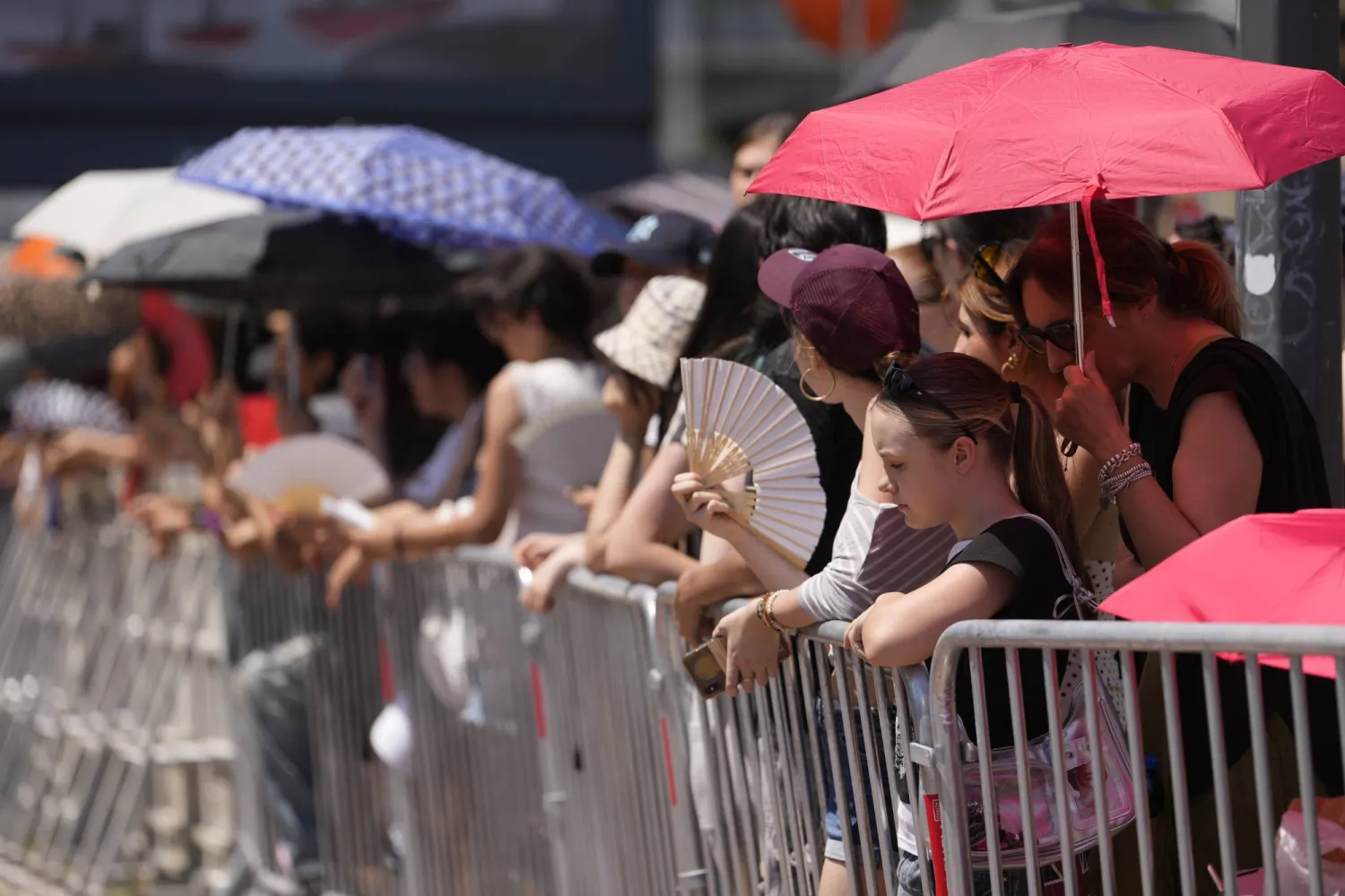  People wait in the heat the arrival of guests of the Prada's Spring/Summer 2027 men's collection presented in Milan, Italy, Sunday, June 21, 2026. (AP) 