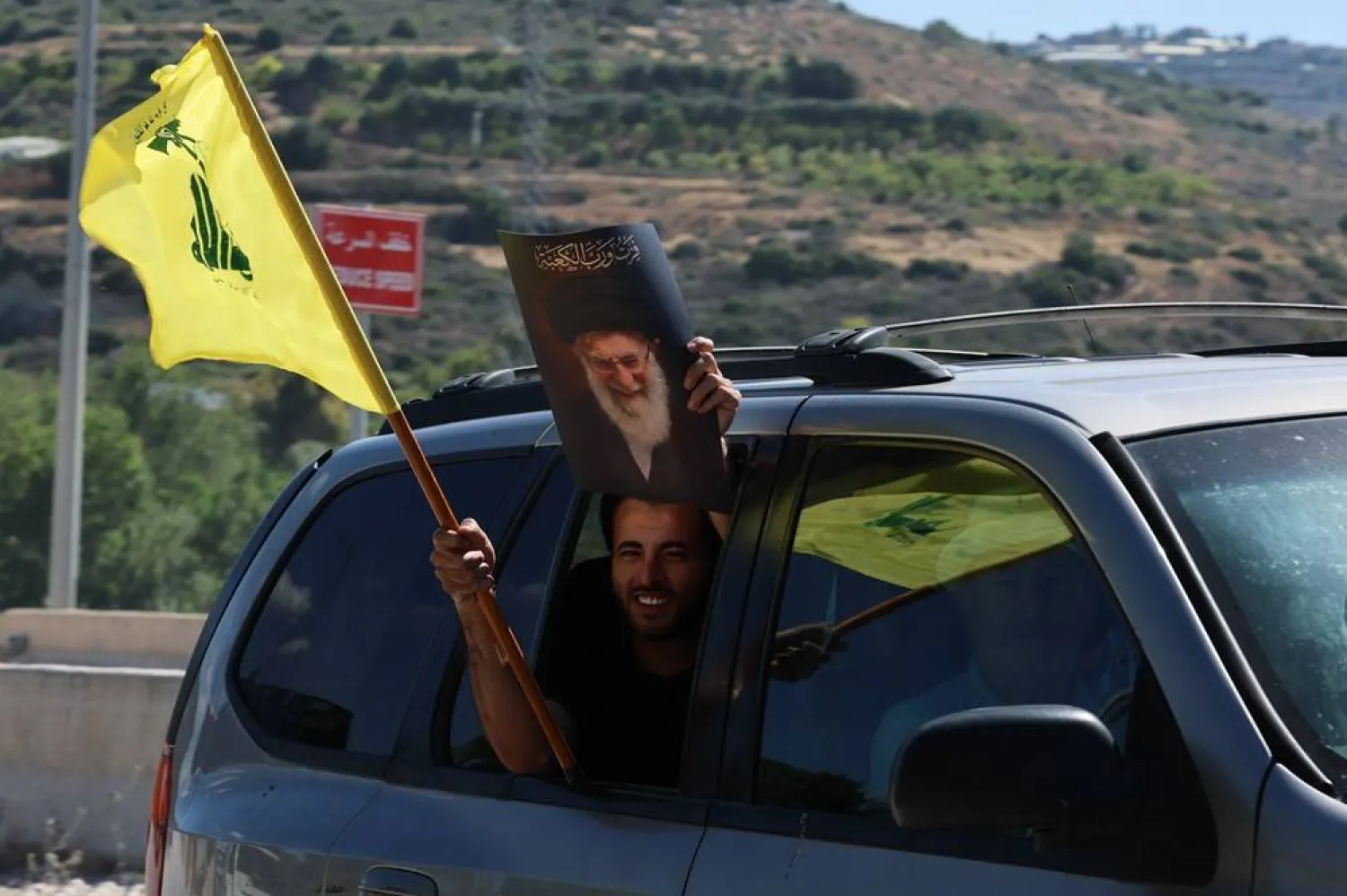 Hezbollah supporter carries a Hezbollah flag and a poster depicting Iran’s slain supreme leader Ali Khamenei at Qasmiyeh Bridge, southern Lebanon, 19 June 2026. (EPA) 