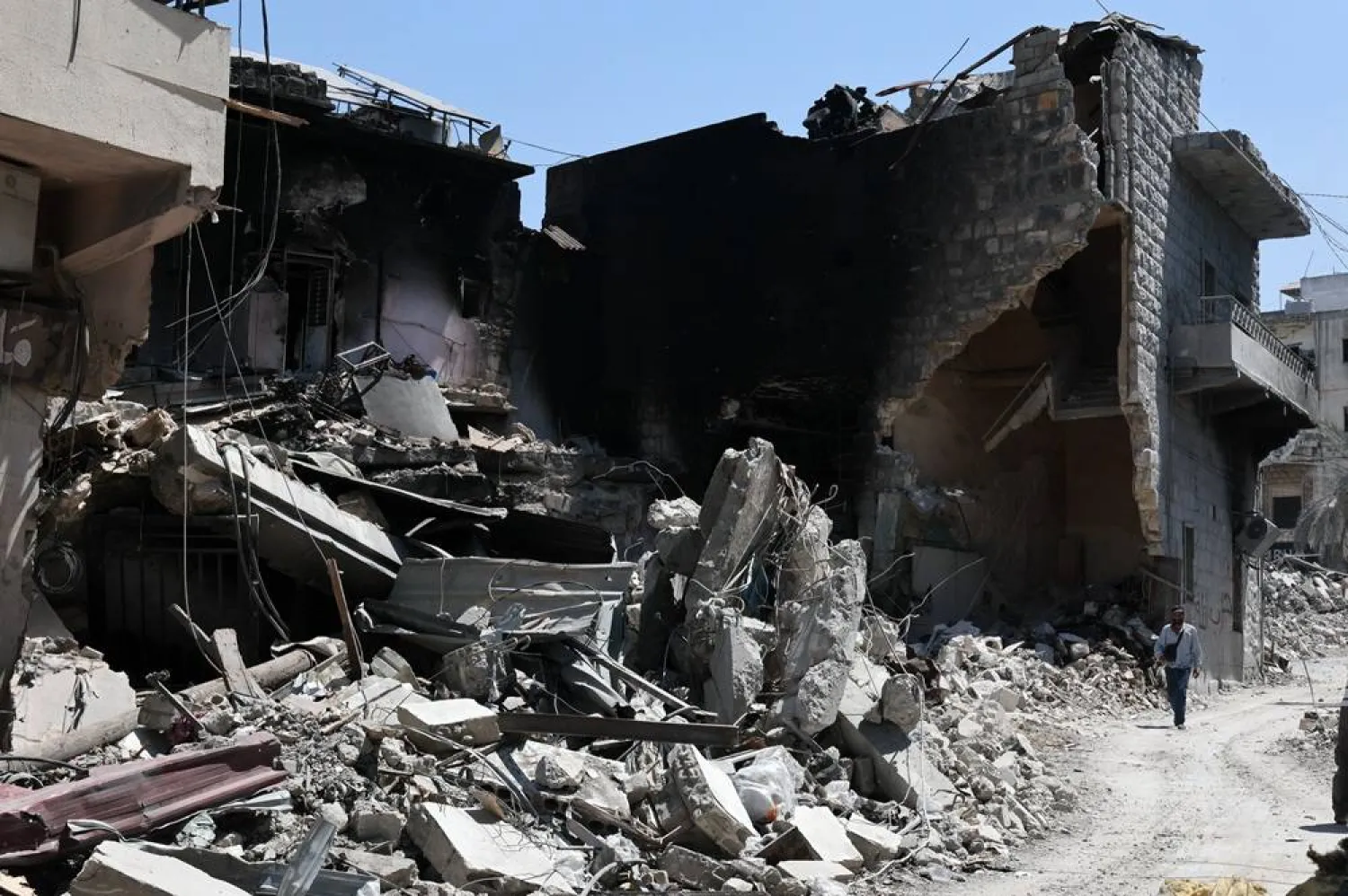 A man walks past a destroyed building targeted by Israeli air strikes on the historic old market in the town of Nabatieh, southern Lebanon, 21 June 2026, following the ceasefire between Israel and Hezbollah. (EPA)
