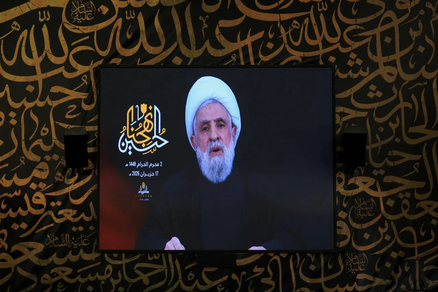 الأمين العام لـ«حزب الله» نعيم قاسم يلقي كلمة متلفزة على شاشة عملاقة في ضاحية بيروت الجنوبية (رويترز)