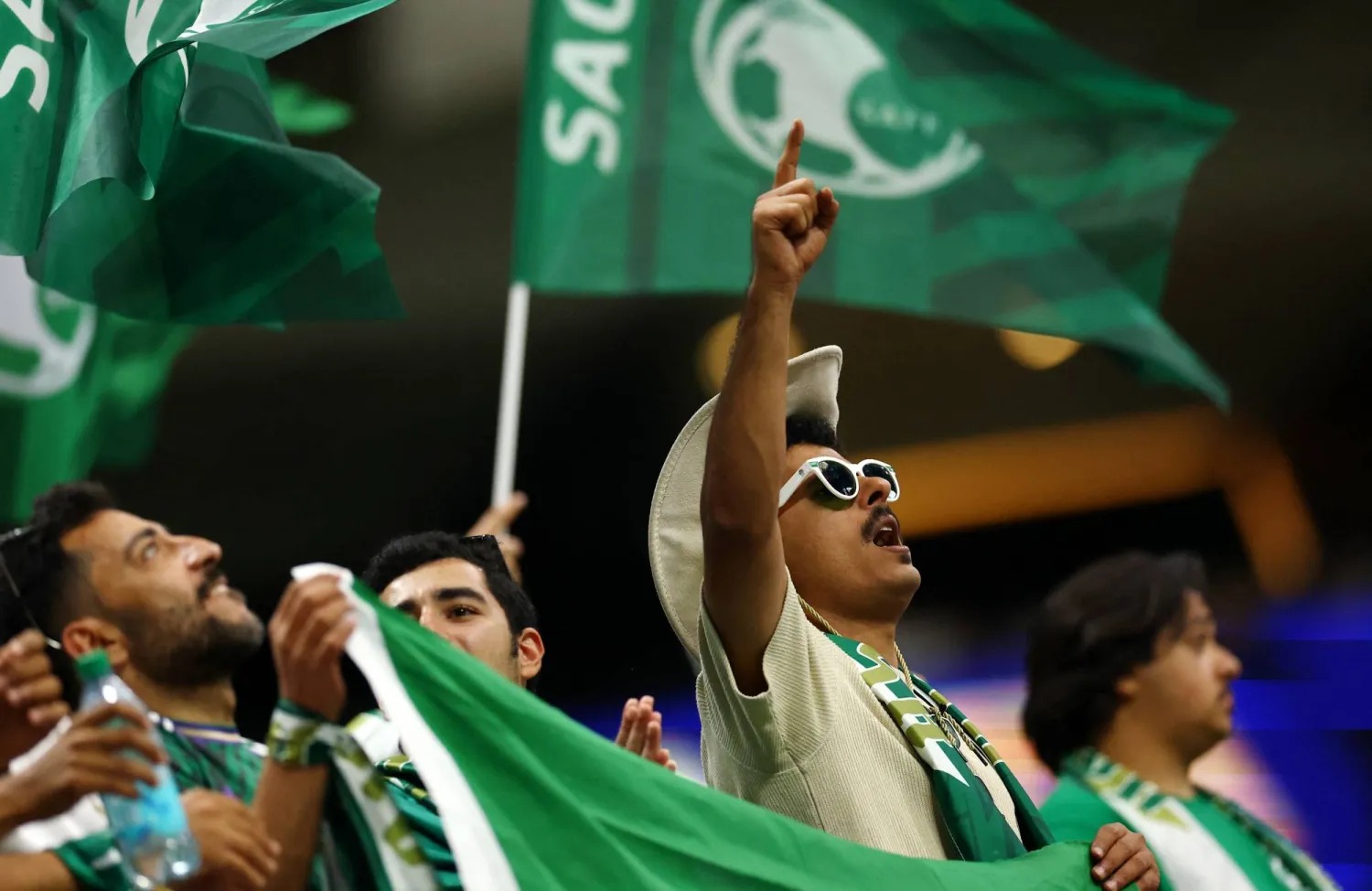 جماهير السعودية تلوّح بالأعلام في المدرجات خلال المباراة (رويترز)
