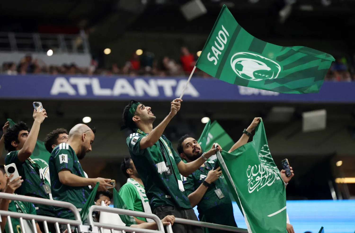 جماهير السعودية تلوّح بالأعلام في المدرجات خلال المباراة (رويترز)
