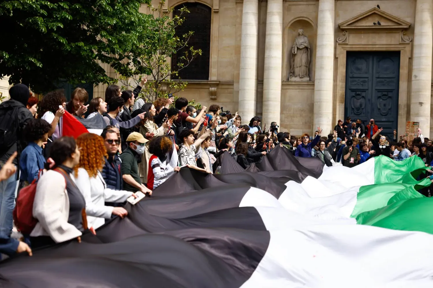 Gazze'ye destek veren öğrenciler, Nisan 2024'te Paris'teki Sorbonne Üniversitesi binası önünde oturma eylemi yaparken (EPA)