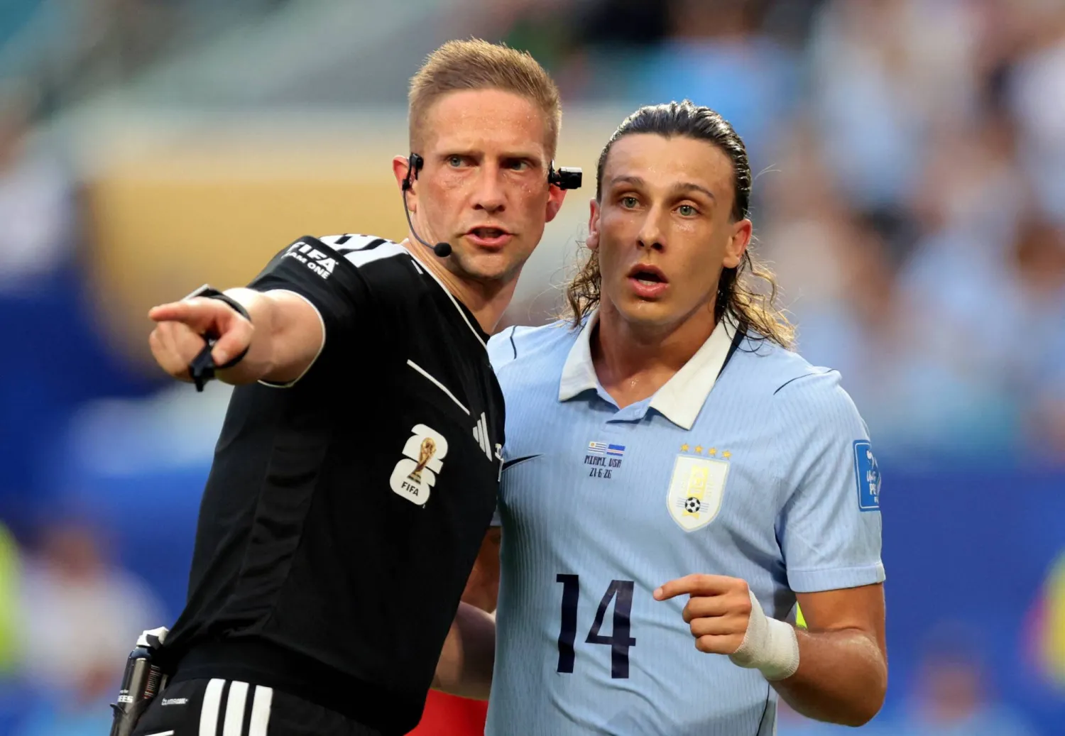 حديث يجمع كانوبيو لاعب منتخب الأوروغواي وحكم اللقاء (رويترز)