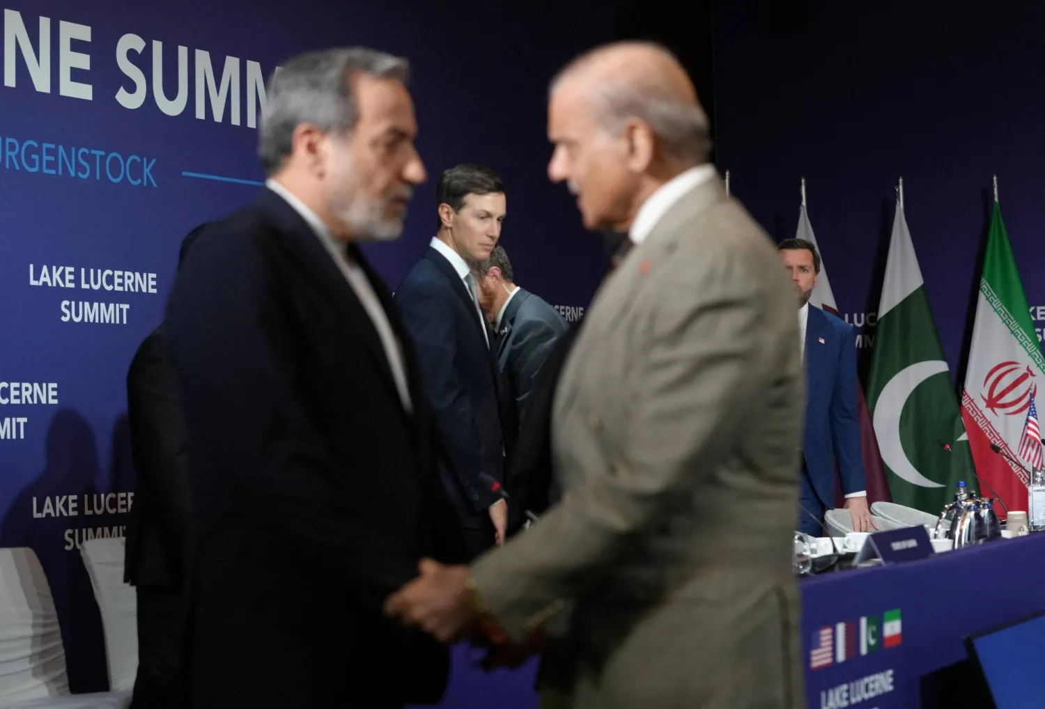 وزير الخارجية الإيراني عباس عراقجي أثناء مصافحته رئيس الوزراء الباكستاني شهباز شريف قبيل انطلاق الاجتماع الرباعي في منتجع بورغنشتوك السويسري (رويترز)