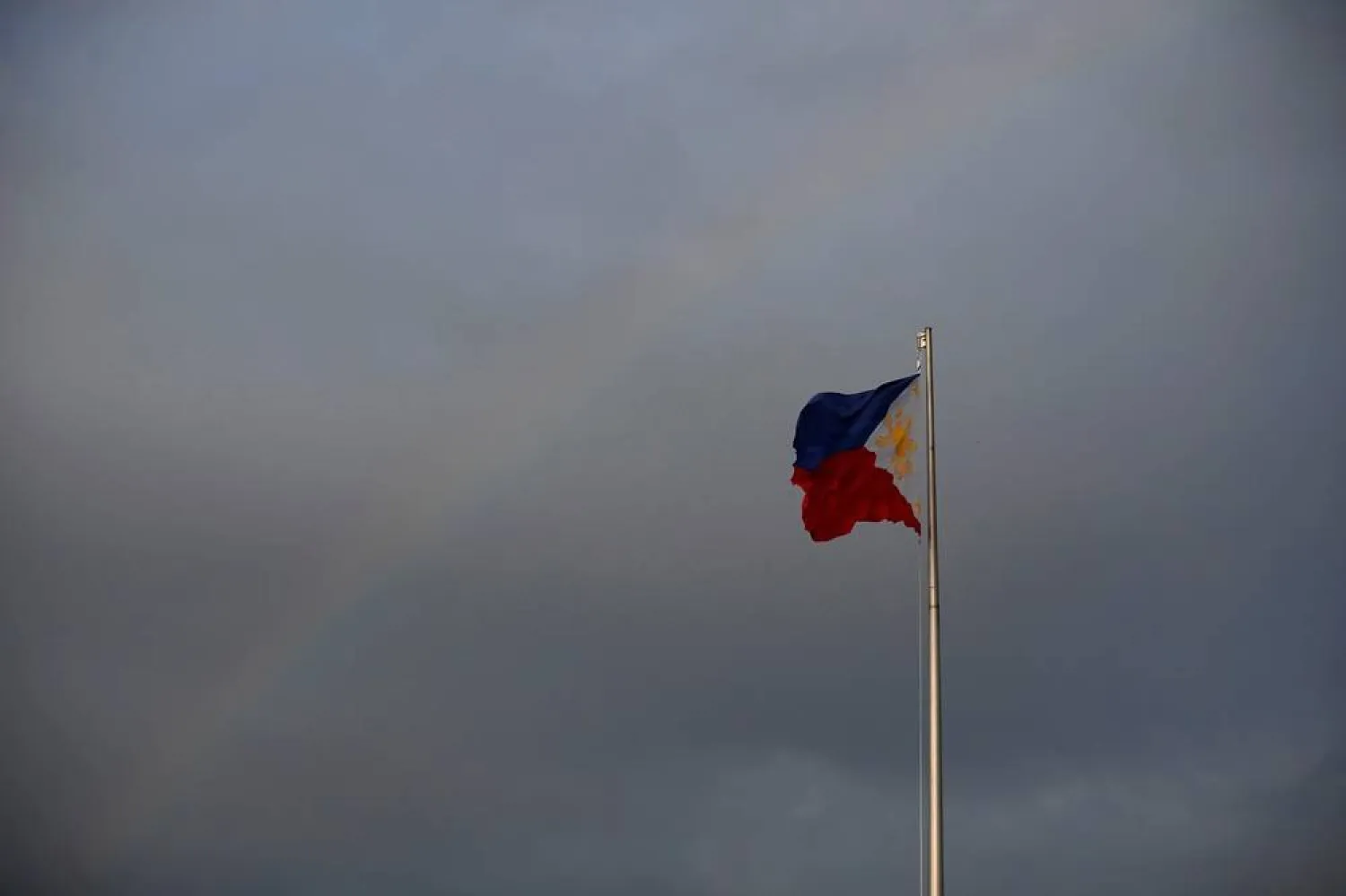 Philippines National Flag is pictured as the rainbow displays over it a day before the annual procession to celebrate Black Nazarene feast day at Quirino Grandstand in Manila, Philippines, January 8, 2020. (Reuters)