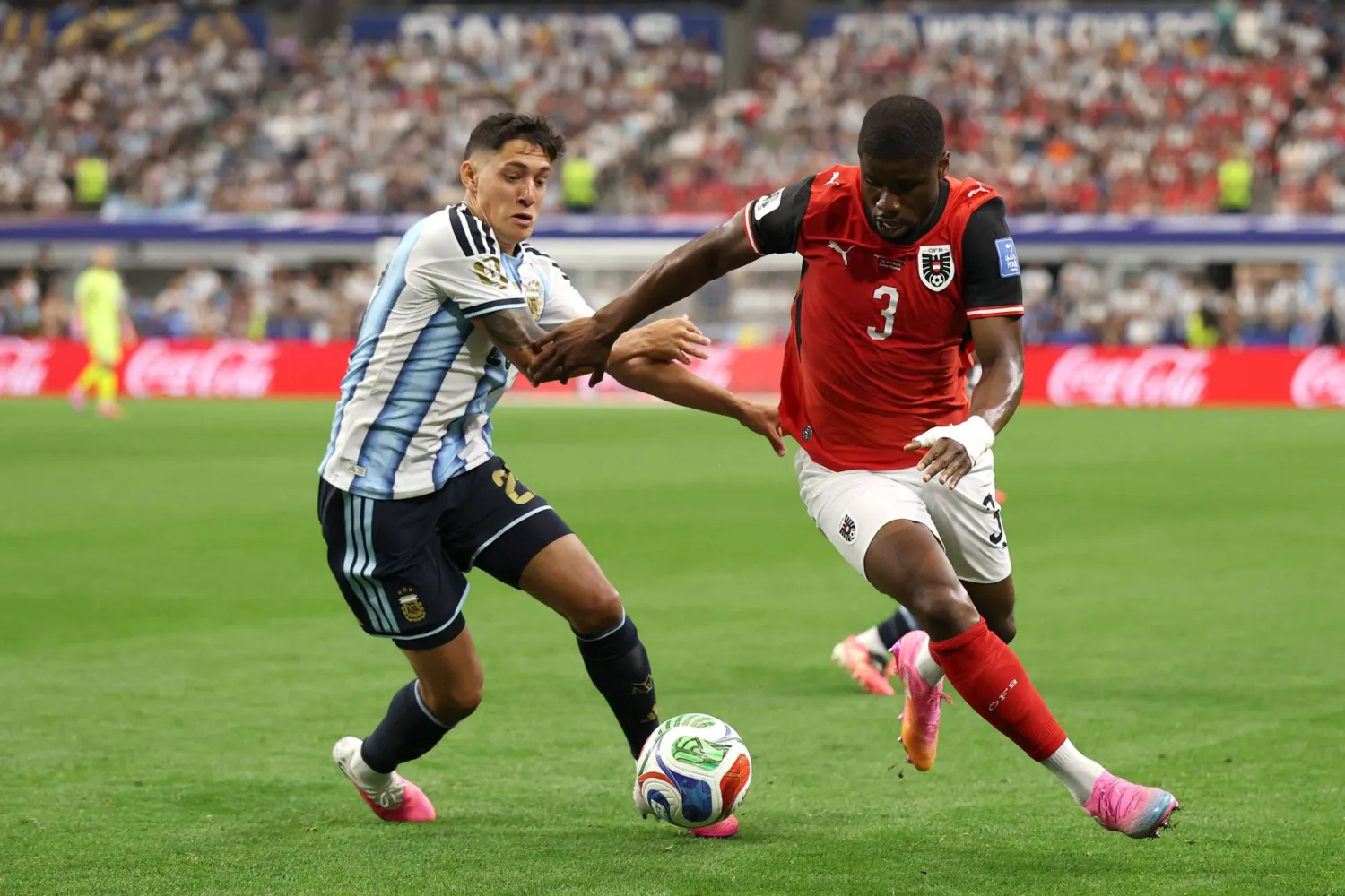 لاعب النمسا كيفن دانسو يسيطر على الكرة تحت ضغط لاعب الأرجنتين ناويل مولينا (أ.ف.ب)