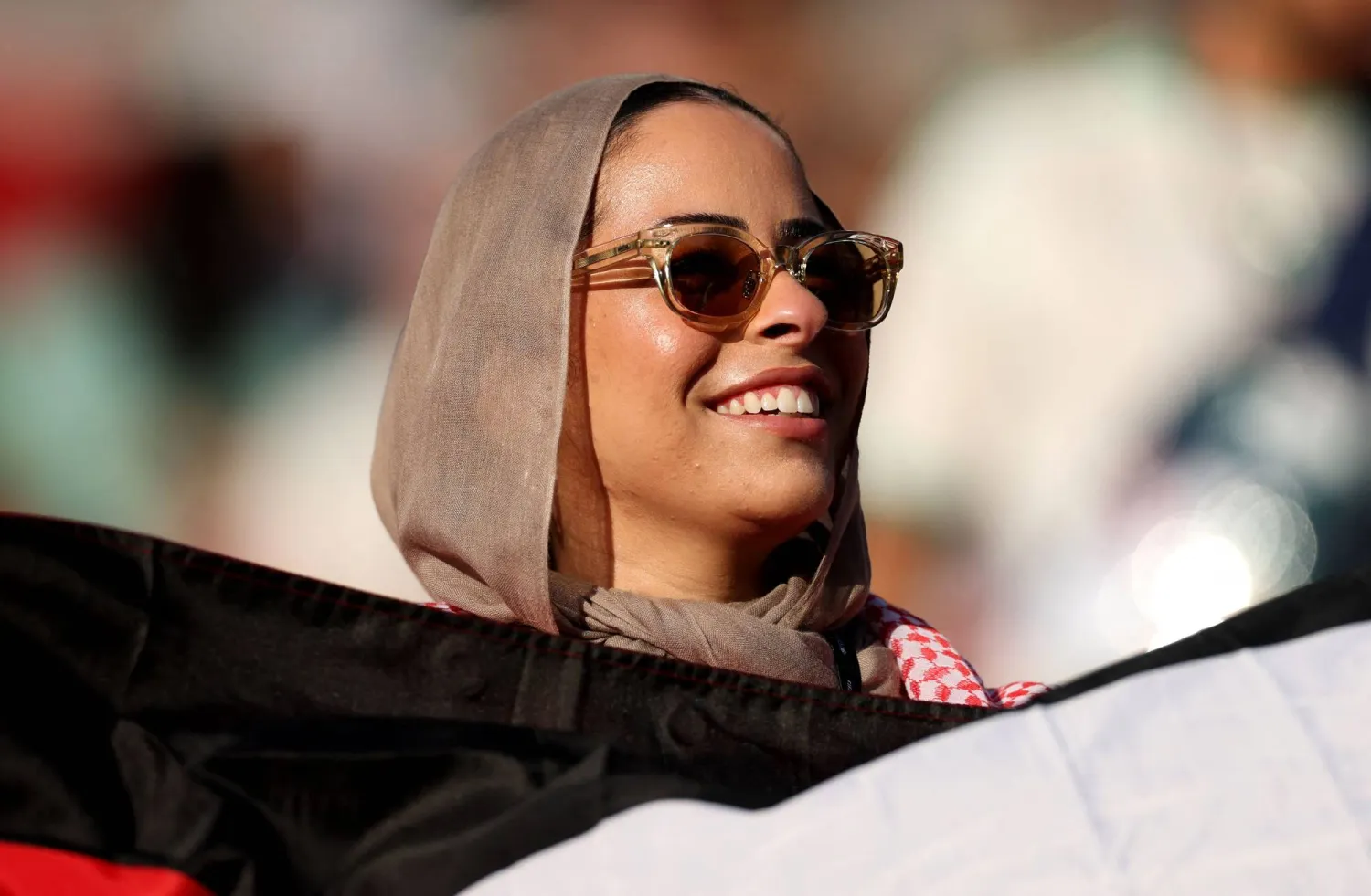 مشجعة أردنية تحمل علم بلادها (أ.ف.ب)