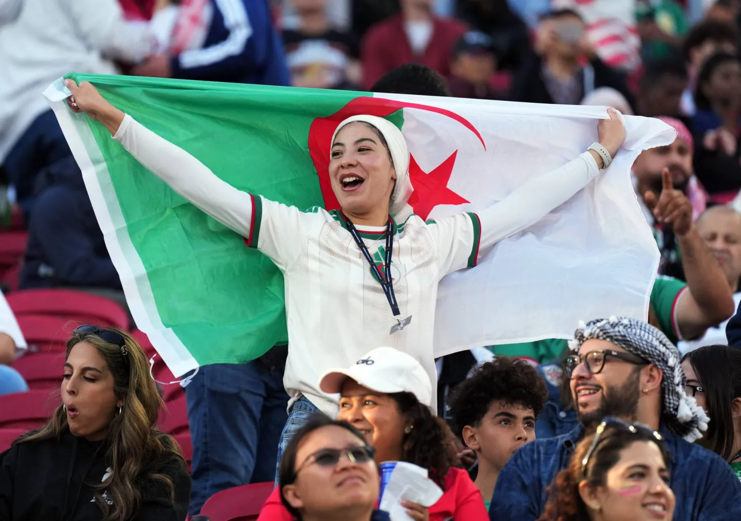 تحمل مشجعة جزائرية علم كبير لبلادها (رويترز)
