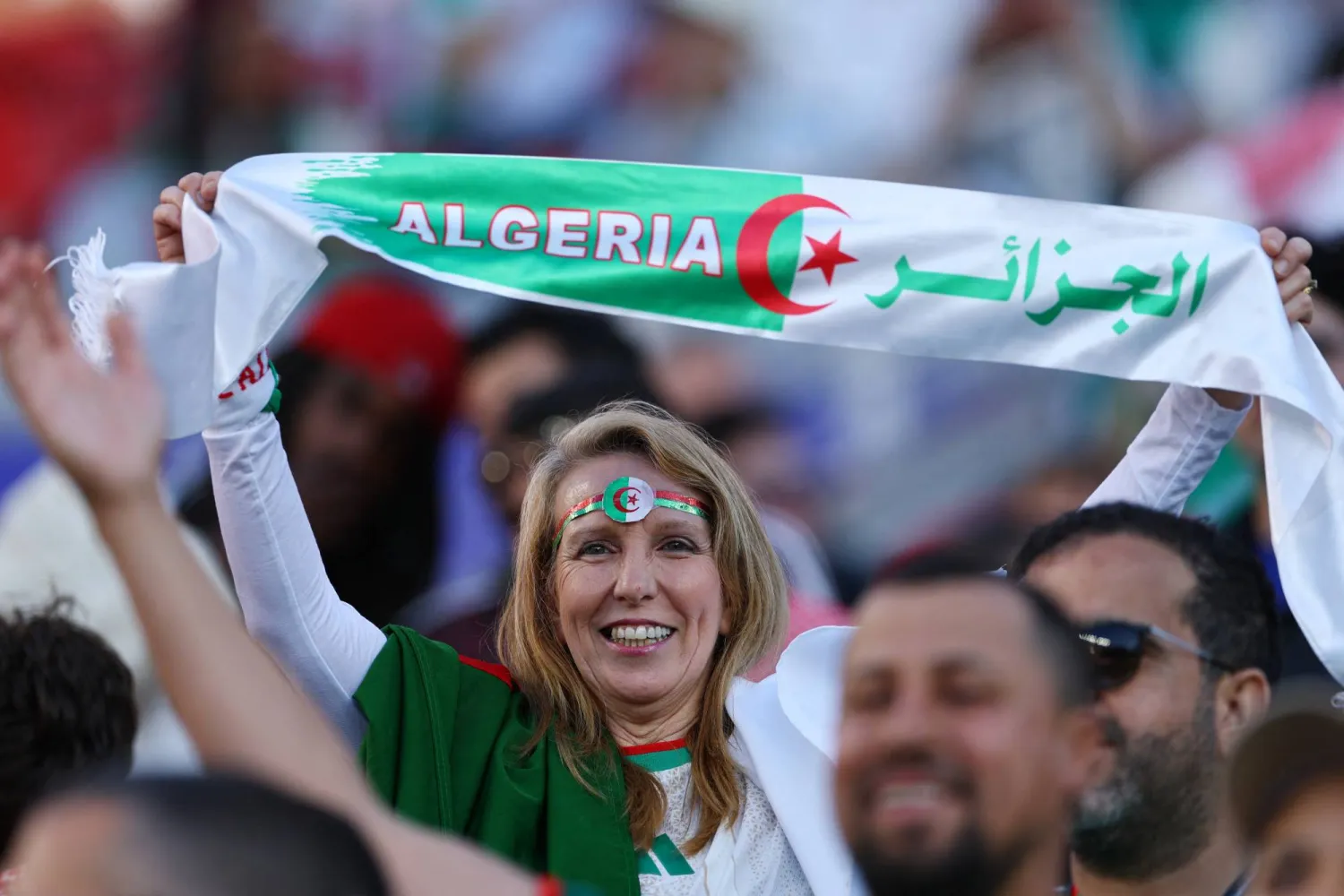 تحمل مشجعة جزائرية علم بلادها (رويترز)